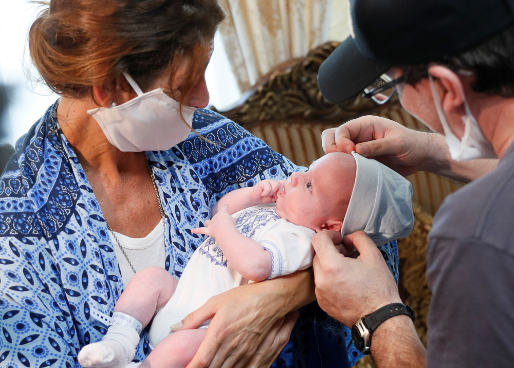 Генетические родители держат ребенка, рожденного суррогатной матерью. Фото GLEB GARANICH / TASS / Scanpix / Leta