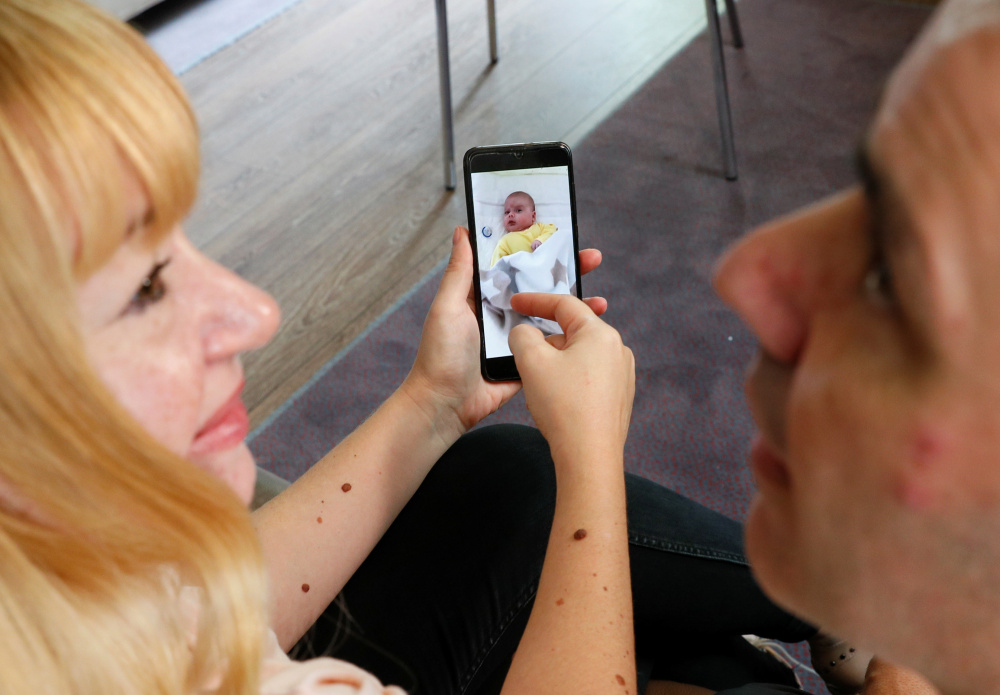 Генетические родители смотрят по видеосвязи на ребенка, рожденного суррогатной матерью. Фото GLEB GARANICH / TASS / Scanpix / Leta