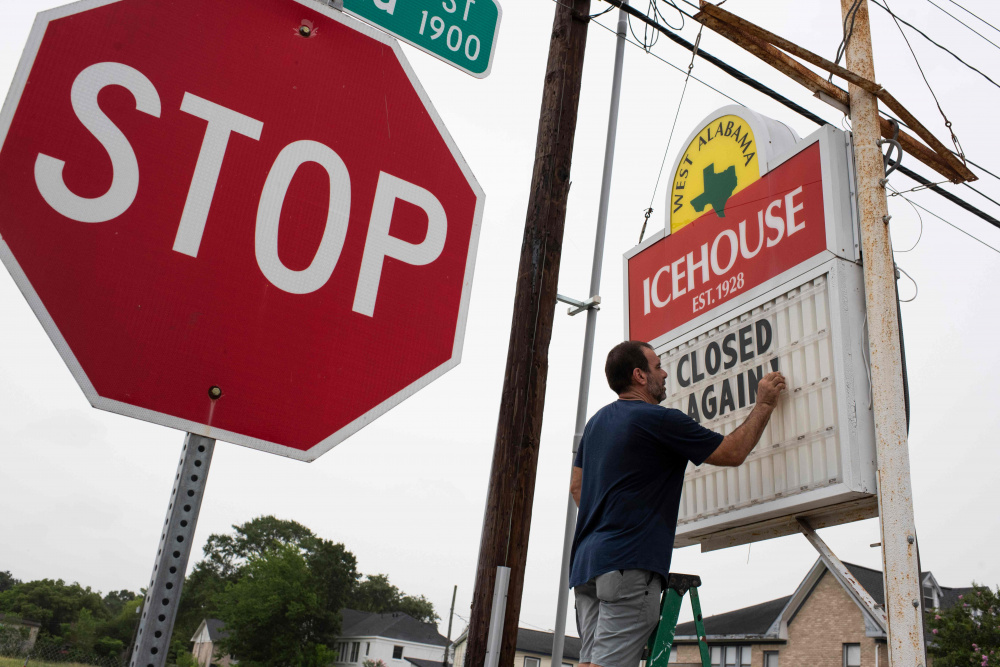 Владелец бара в Хьюстоне (Техас) меняет вывеску на «Снова закрыто». Фото Mark Felix / AFP/ Scanpix/ Leta