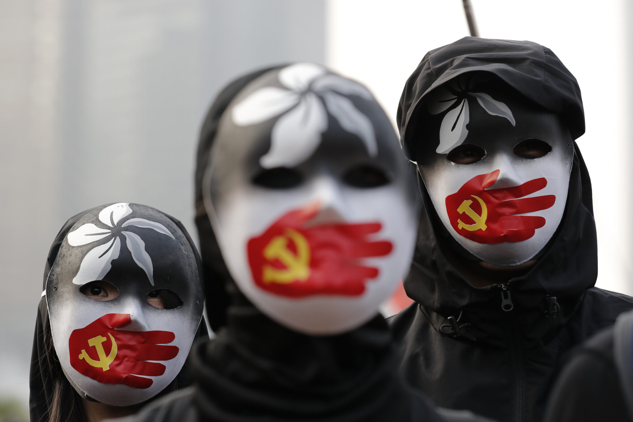 Протестующие в масках выступают в поддержку уйгуров. Фото AP Photo/Lee Jin-man/Scanpix/Leta