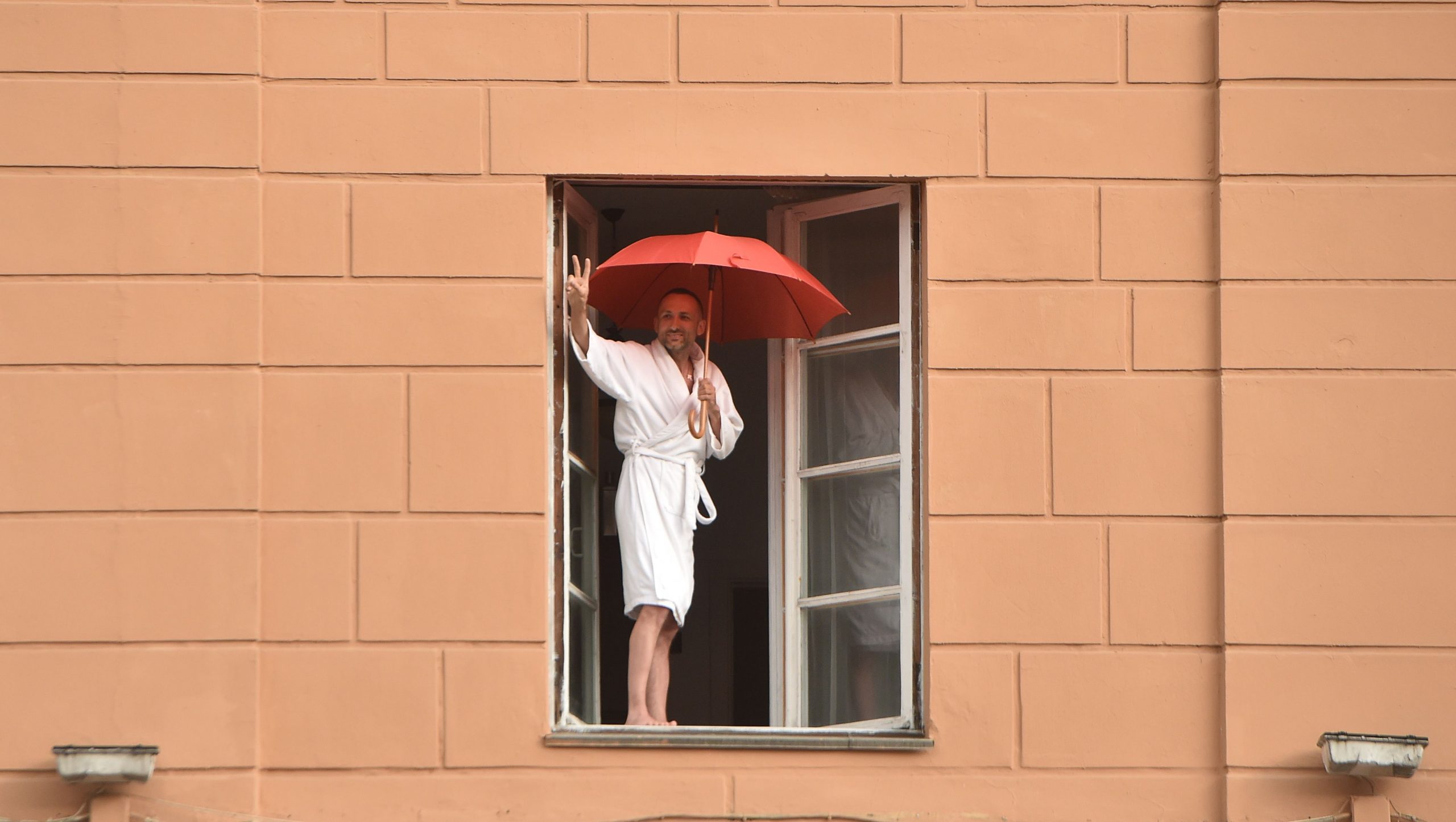 Житель Минска поддерживает из окна движущуюся толпу протестующих. Фото Sergei GAPON / AFP/Scanpix/Leta
