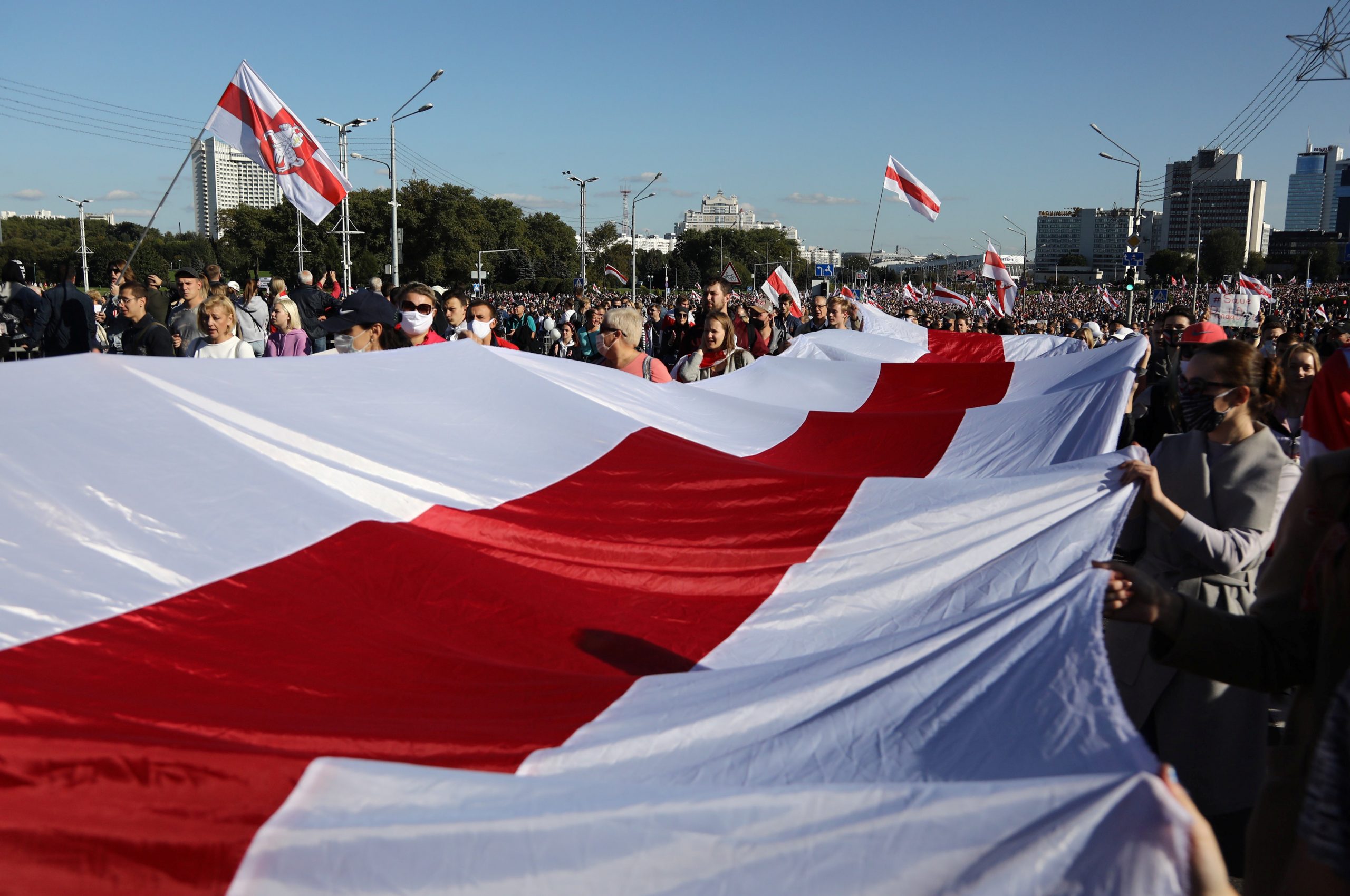 Протестующие принесли с собой огромные стяги оппозиционного флага. Фото Tut.By via REUTERS/Scanpix/Leta