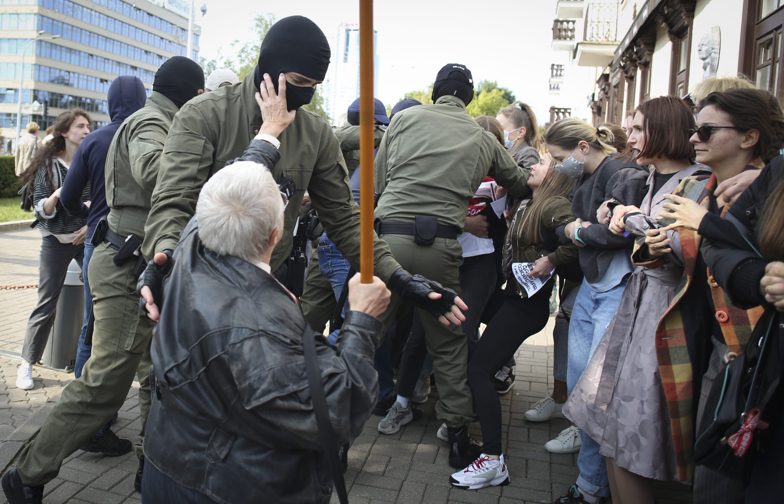 Пожилая участница протеста пытается сорвать балаклаву с силовика. Фото Tut.by via AP/Scanpix/Leta