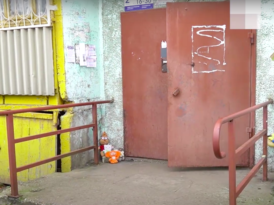 К подъезду, где произошло убийство, жители Рыбинска несут игрушки. Скриншот из видео 79.ru