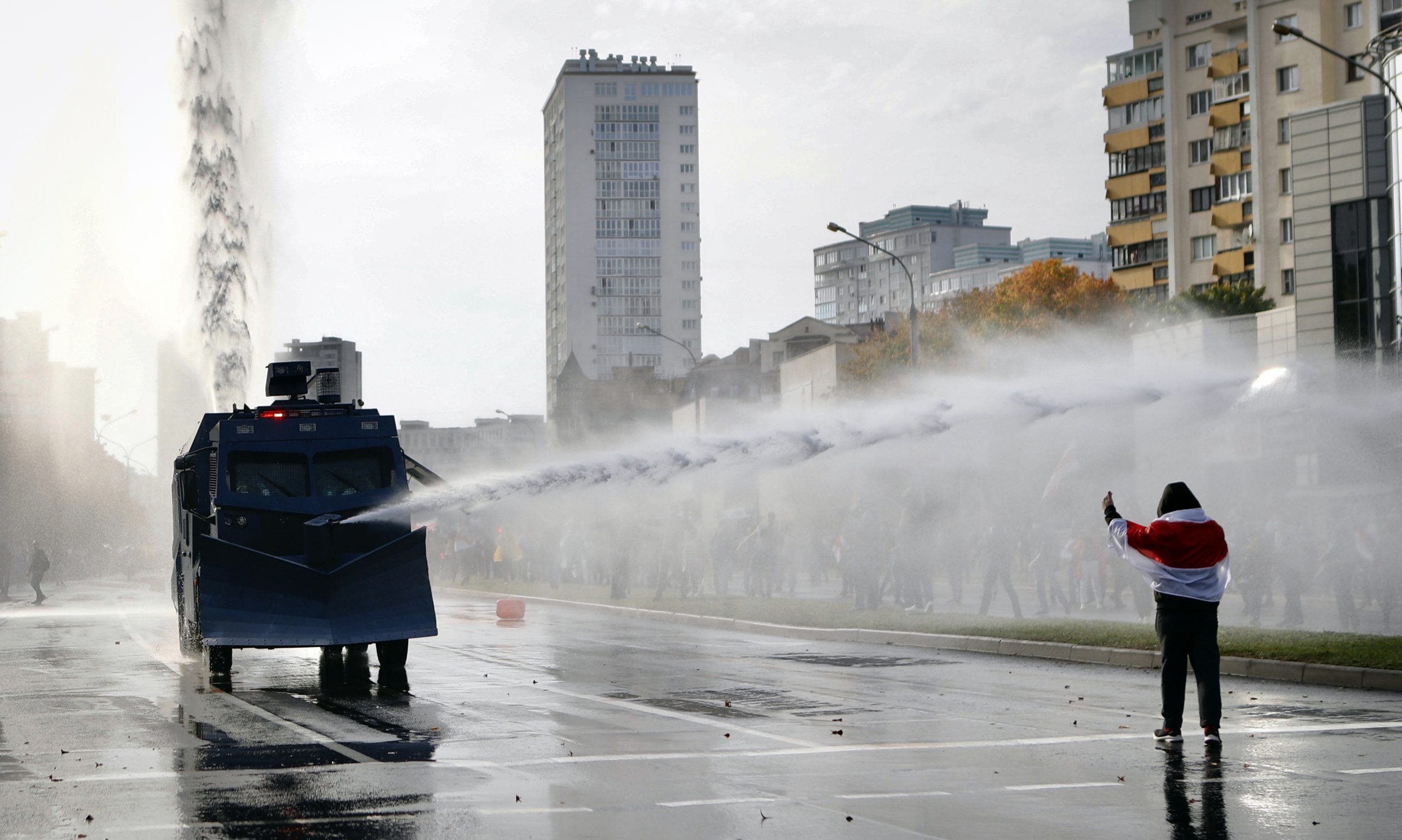 Водомет и участник акции протеста в Минске 4 октября. Фото AP Photo/Scanpix/Leta
