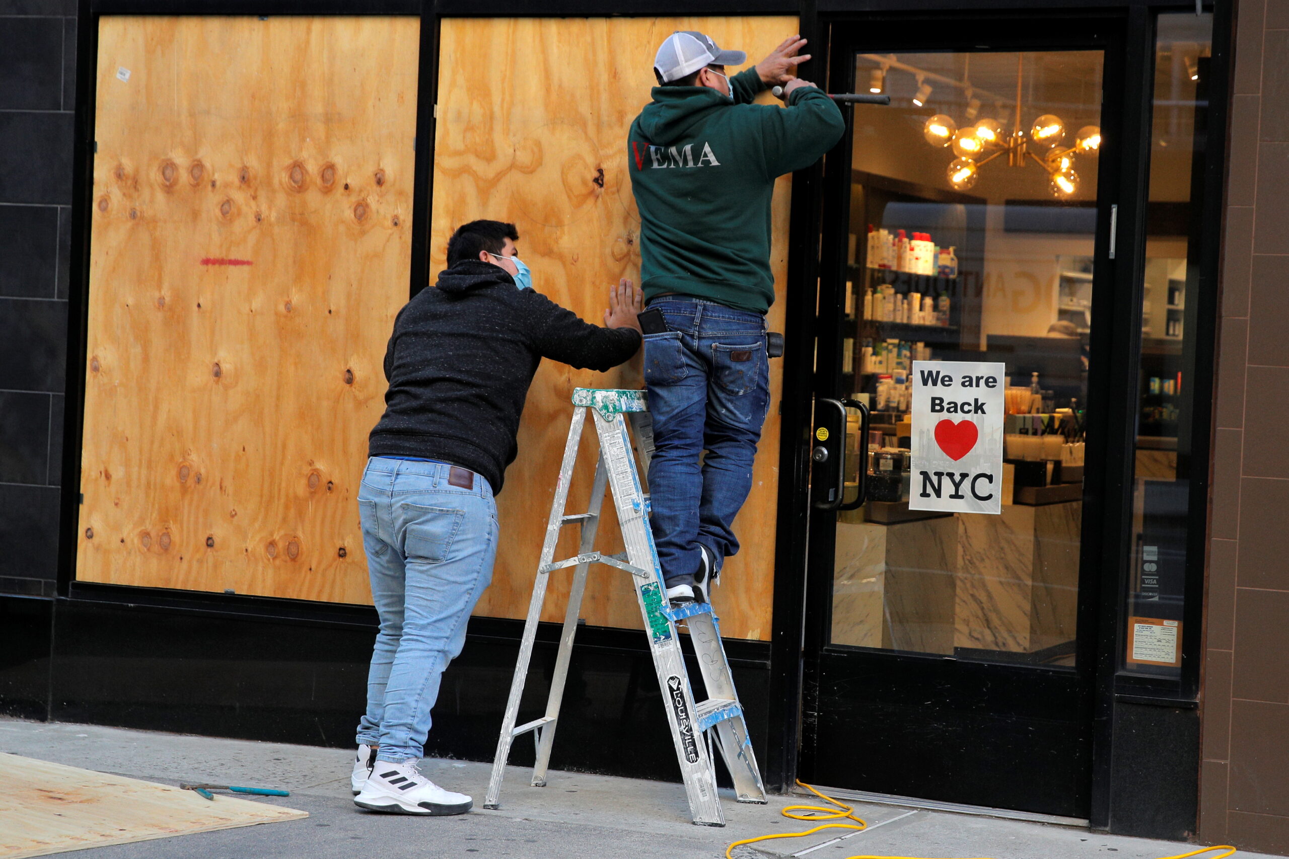 Рабочие заколачивают витрины в магазине Нью-Йорка. Фото REUTERS/Brendan McDermid/Scanpix/Leta