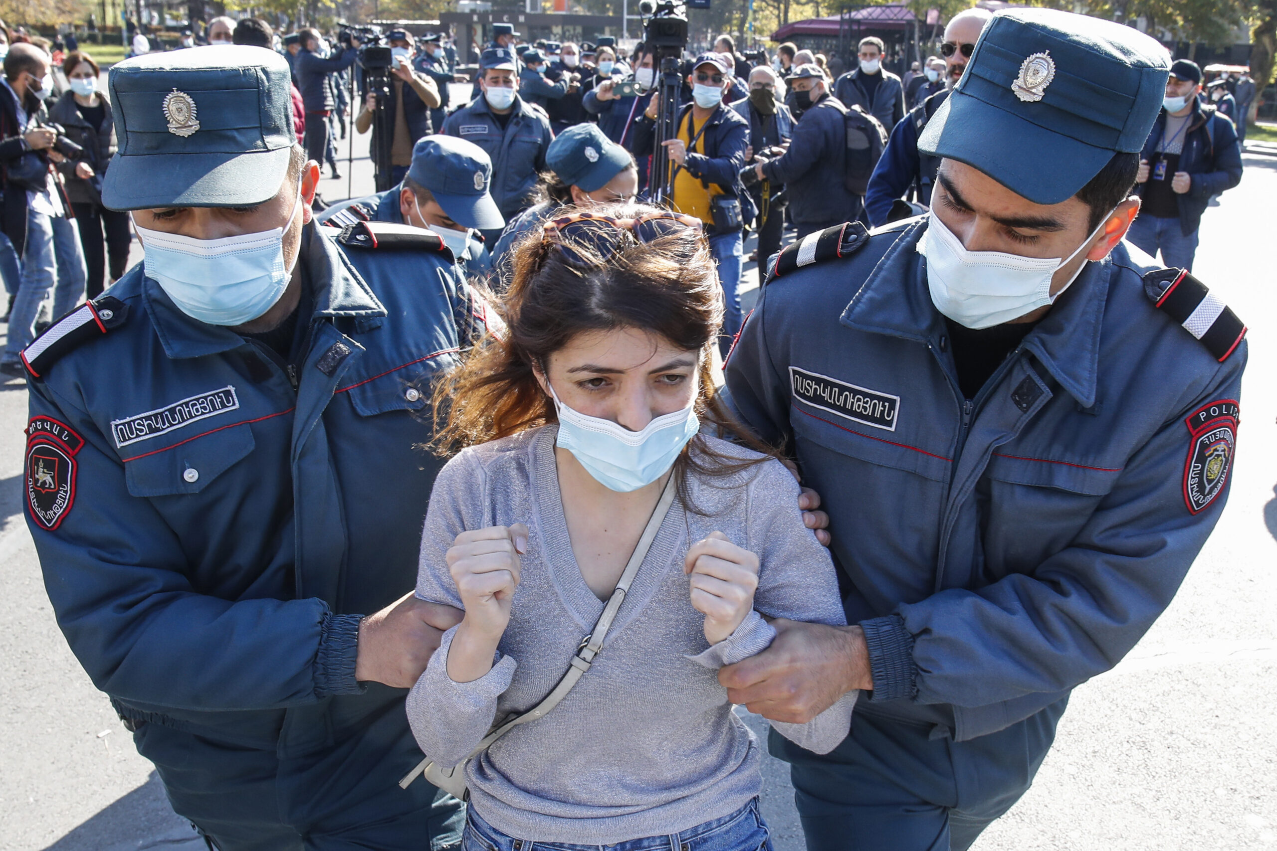 Полицейские уводят задержанную девушку. Фото AP Photo/Dmitri Lovetsky/Scanpix/Leta