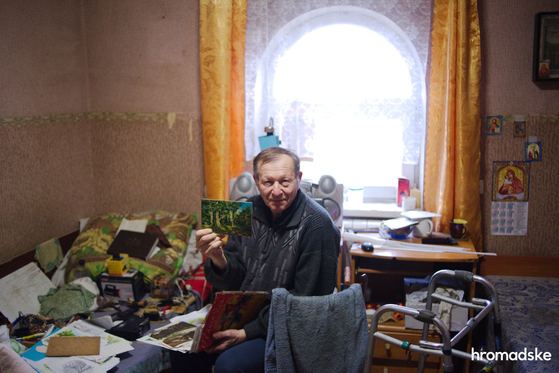 Александр Карих, 70 лет, показывает свои рисунки, нарисованные в Доме милосердия. Фото: Макс Левин/hromadske