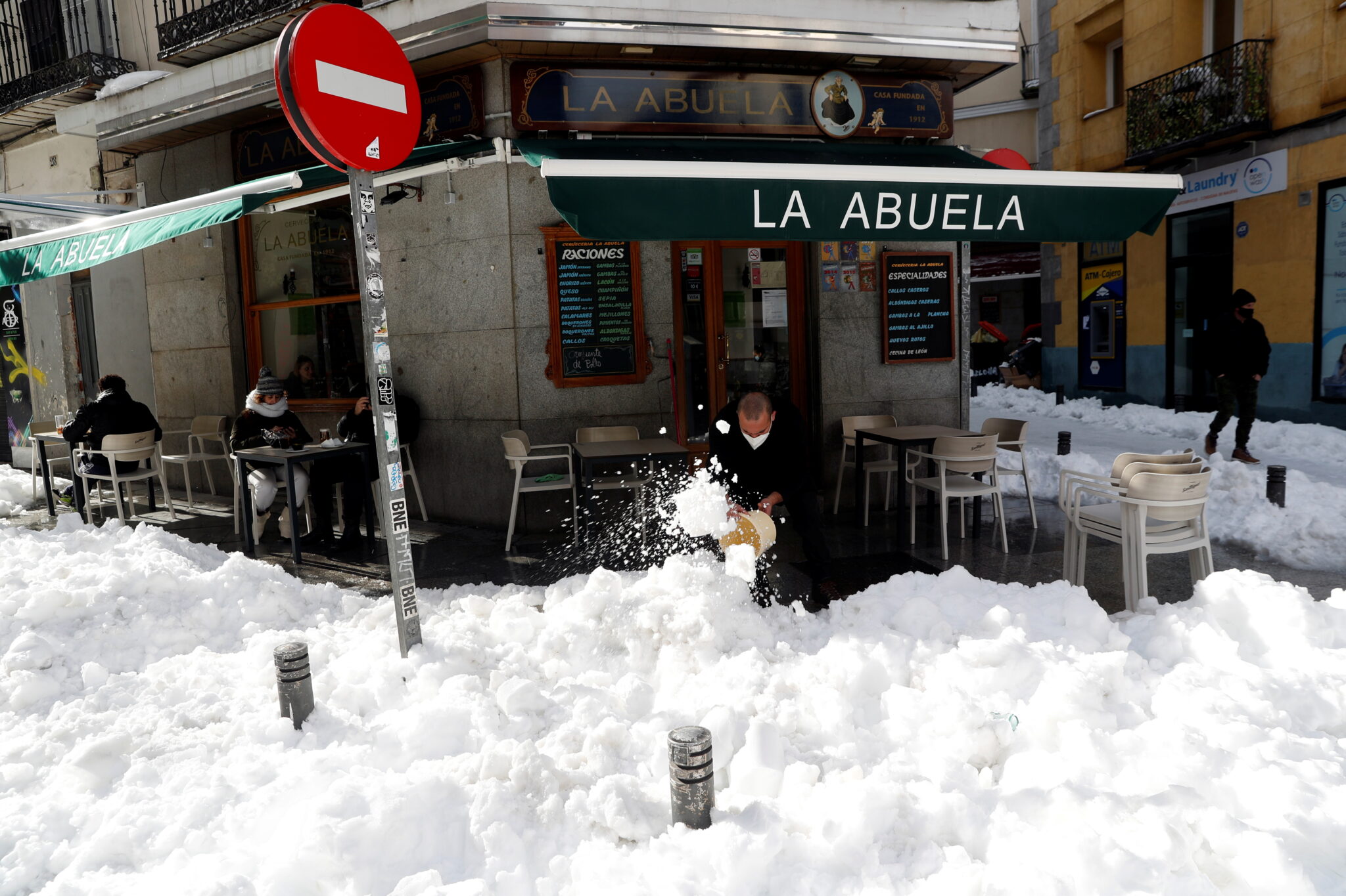 Работник кафе расчищает сугробы в Мадриде. Фото REUTERS/Susana Vera/Scanpix/Leta