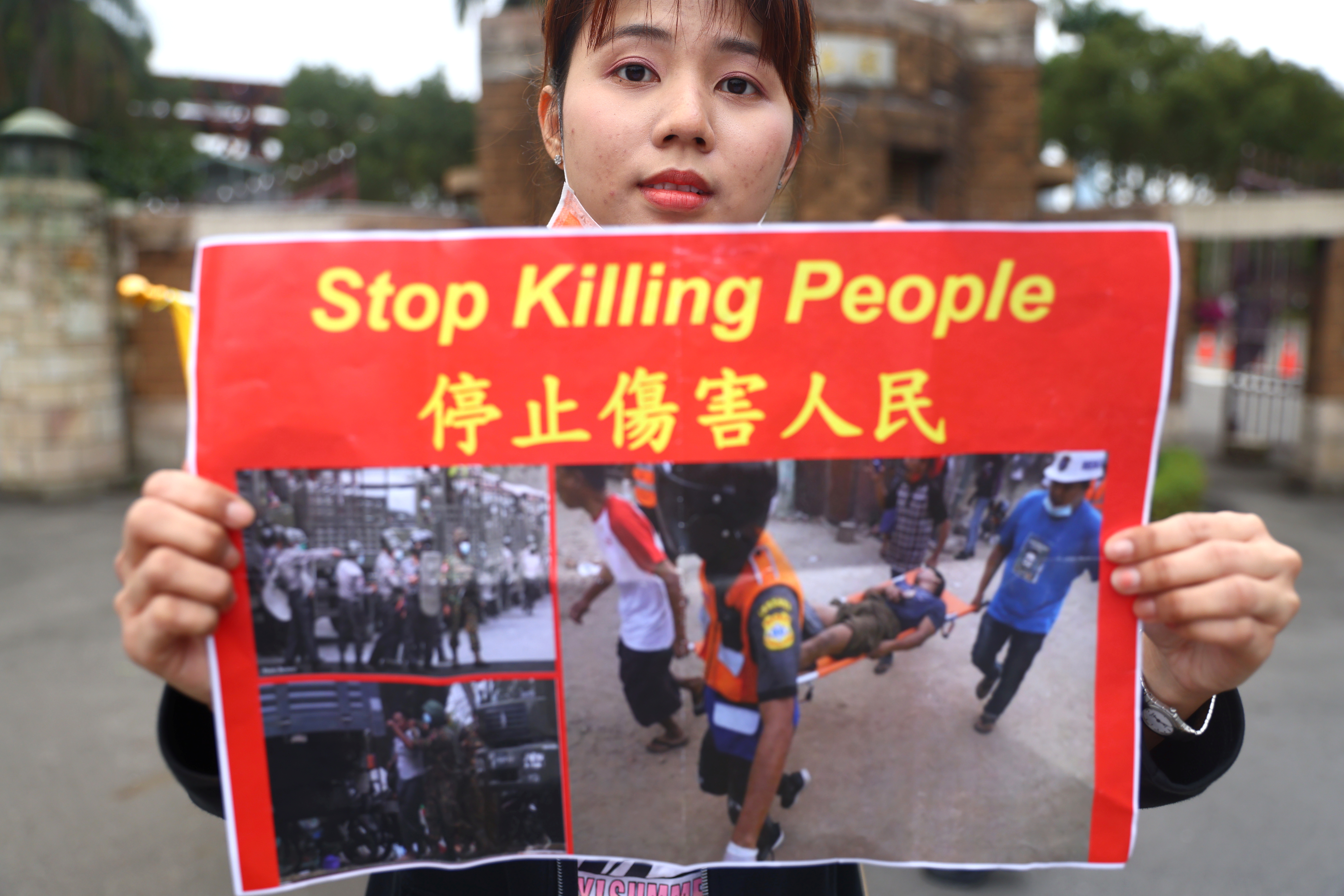 Активистка с плакатом с призывом остановить убийства протестующих. Фото REUTERS/Ann Wang/Scanpix/Leta