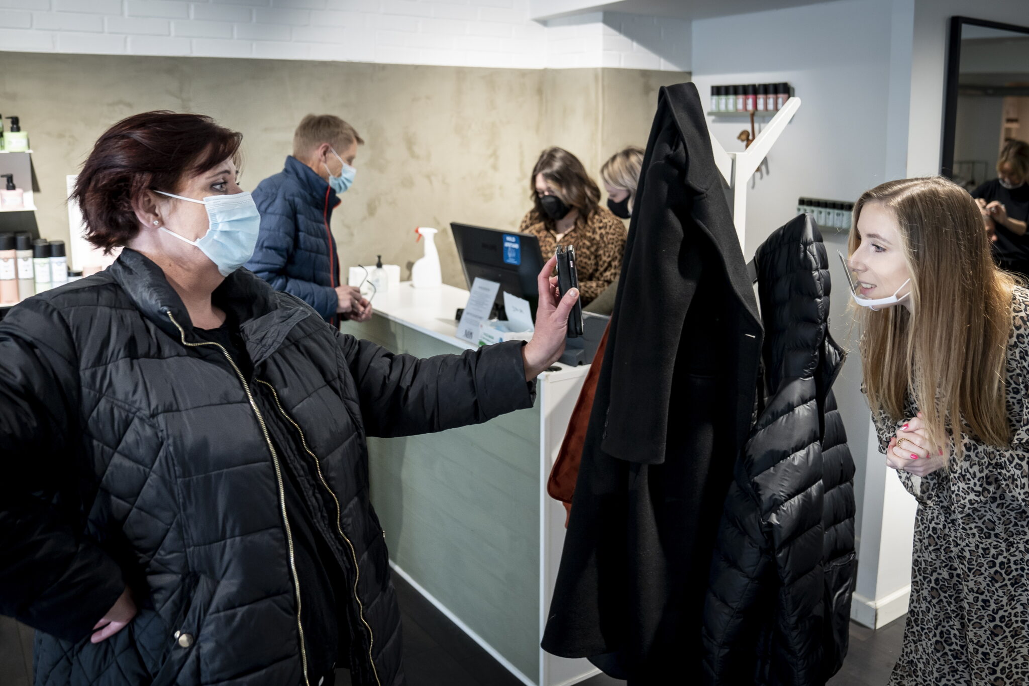 Женщина показывает отрицательный тест на коронавирус в салоне красоты. Фото  EPA/Mads Claus Rasmussen /Scanpix/Leta