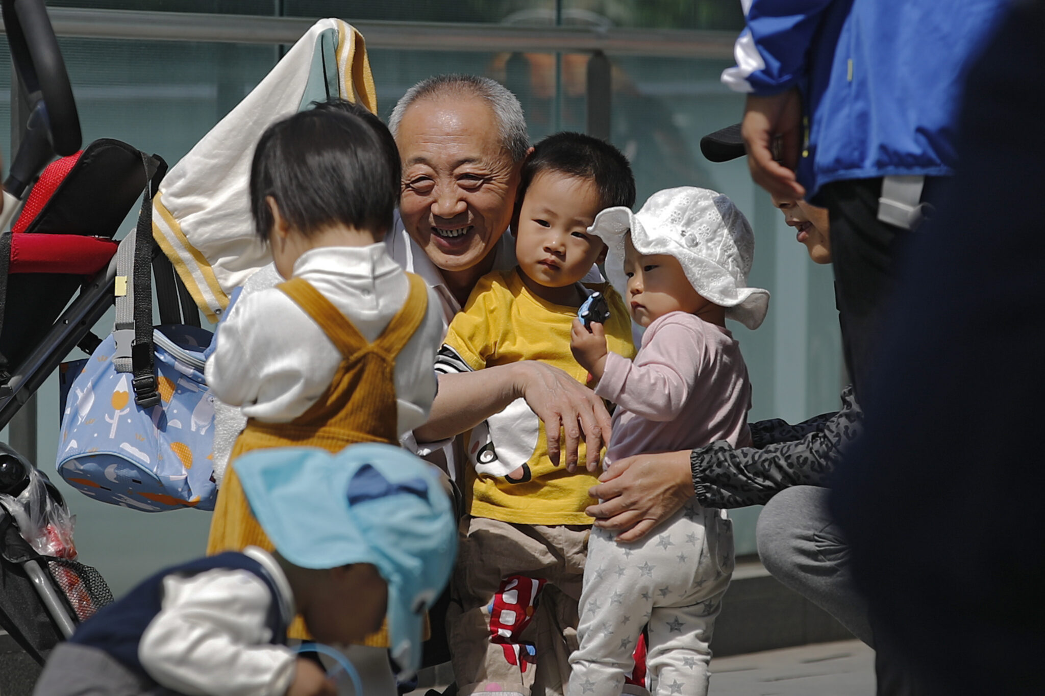 Пожилой мужчина с детьми в Китае. Фото Andy Wong / TASS / Scanpix / Leta