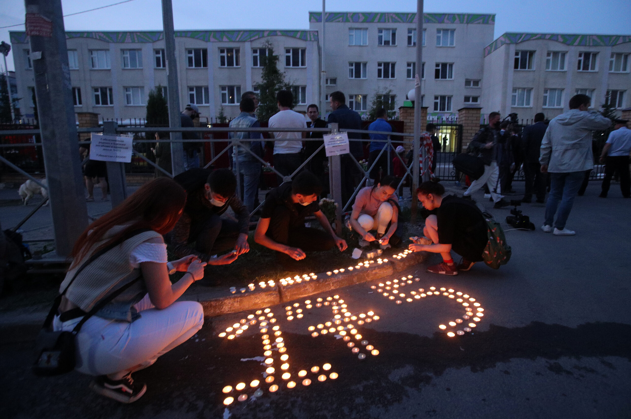 Люди выкладывают свчеами цифру 175 у школы. Фото Yegor Aleyev / TASS / Scanpix / Leta