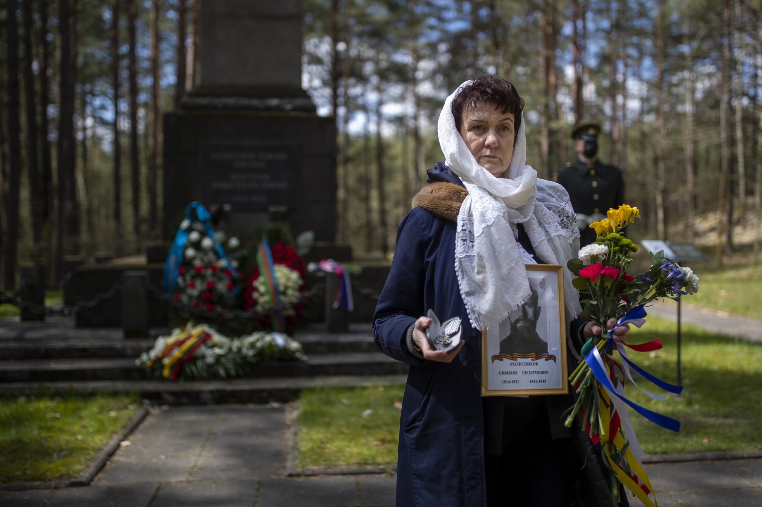 Женщина с портретом родственника у мемориала в Вильнюсе. Фото  (AP Photo/Mindaugas Kulbis/Scanpix/Leta
