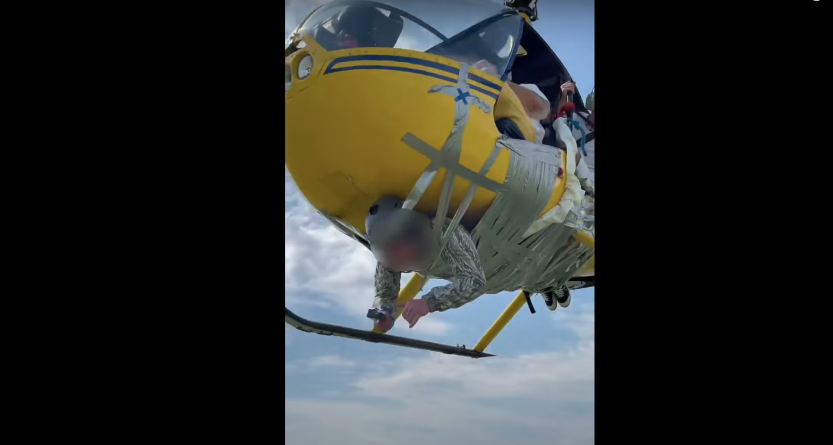Приклеенный скотчем к вертолету мужчина. Скриншот видео YouTube Михаил Литвин