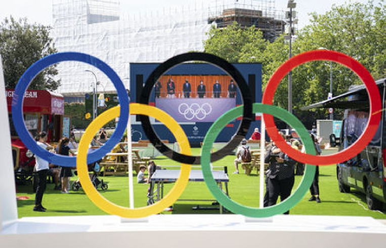 Болельщики наблюдают за церемонией открытия Олимпиады в Токио на большом экране за пределами Национального стадиона. Фото AP/Scanpix/Leta