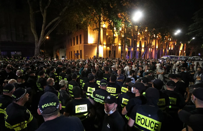 Гомофобно настроенные радикалы и националисты собрались на контракцию. Полиция отделила две группы кордоном. Фото Irakli Gedenidze / Reuters / Scanpix / LETA