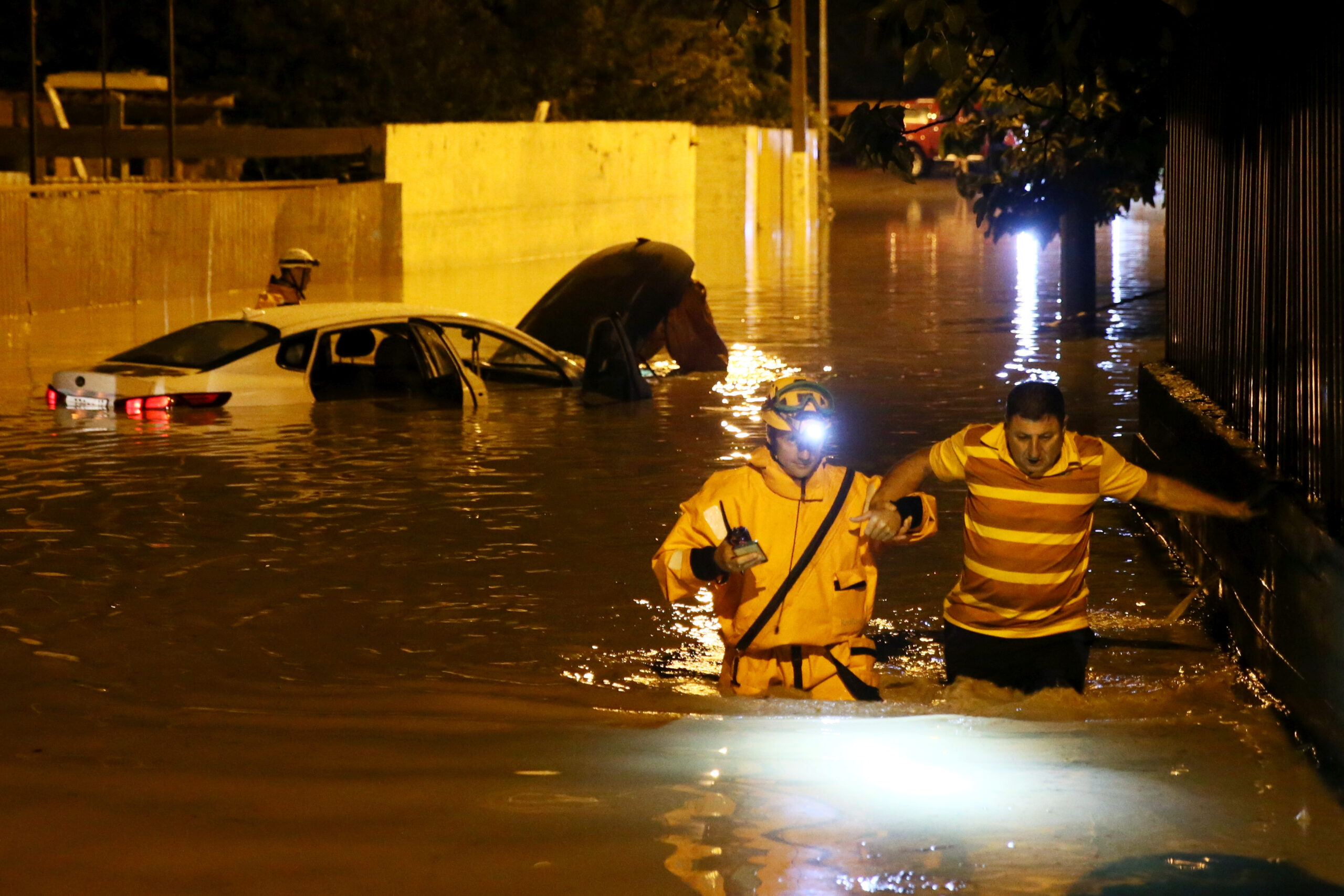 Спасатель помогает выбраться мужчине перейти затопленную улицу. Фото  Dmitry Feoktistov/TASS/Scanpix/Leta