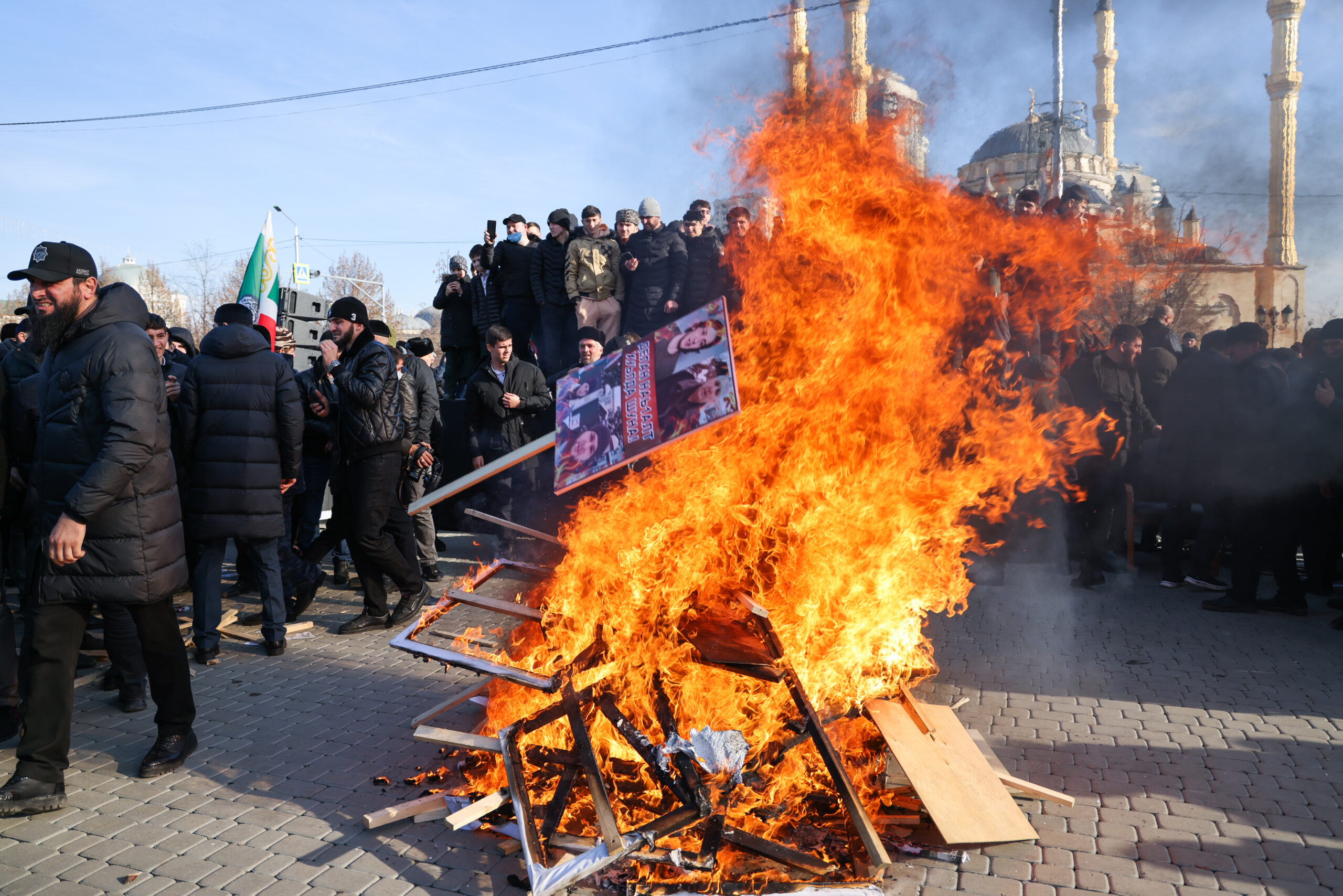 Люди сжигают плакаты и портреты во время акции протеста в центре Грозного против семьи Янгулбаевых, 2 февраля 2022 года. Фото Yelena Afonina/TASS/Scanpix/Leta