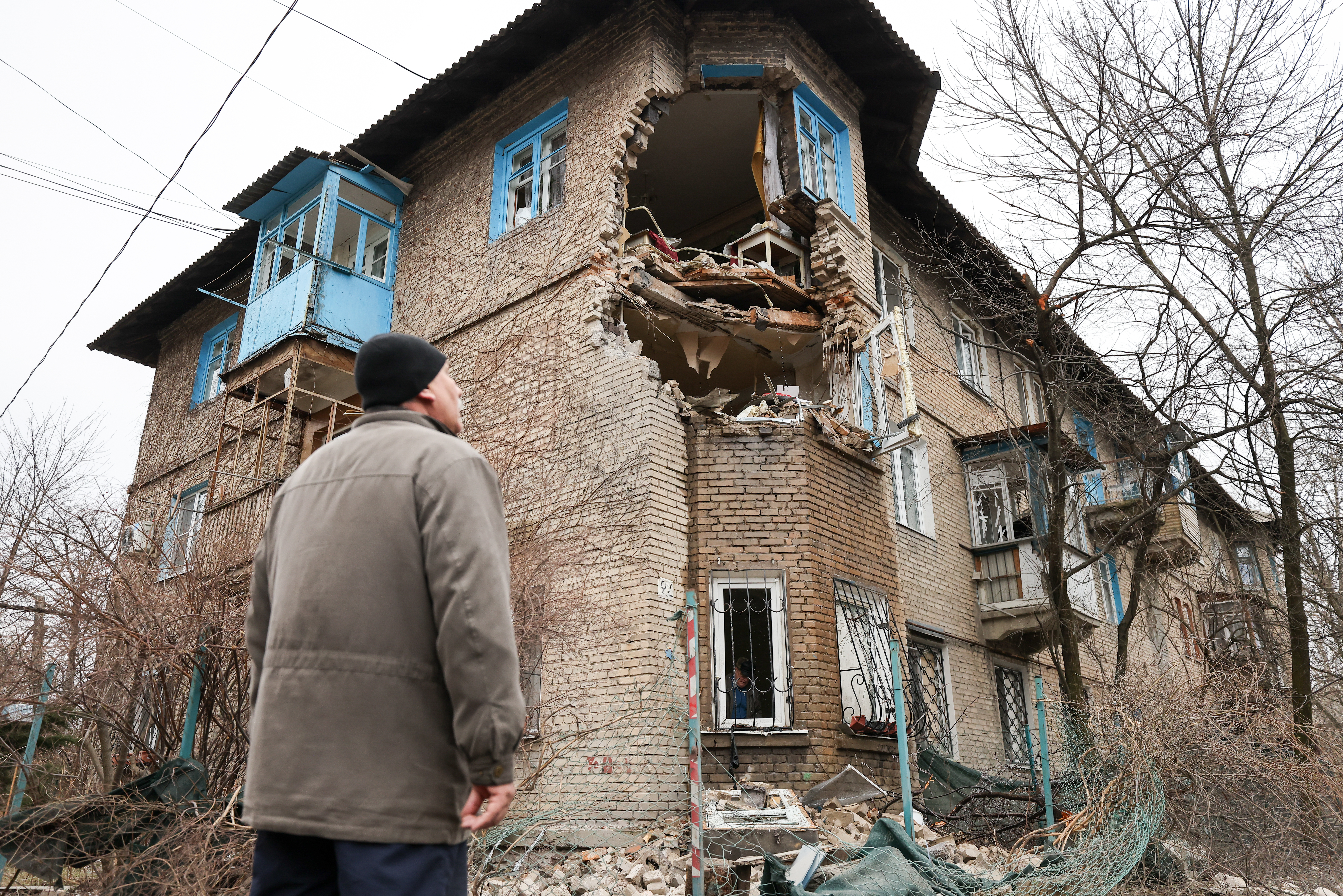 Мужчина смотрит на поврежденное после обстрела здание на улице Миронова в Донецке. 27 февраля 2022 года. Фото Alexander Ryumin/TASS/Scanpix/LETA