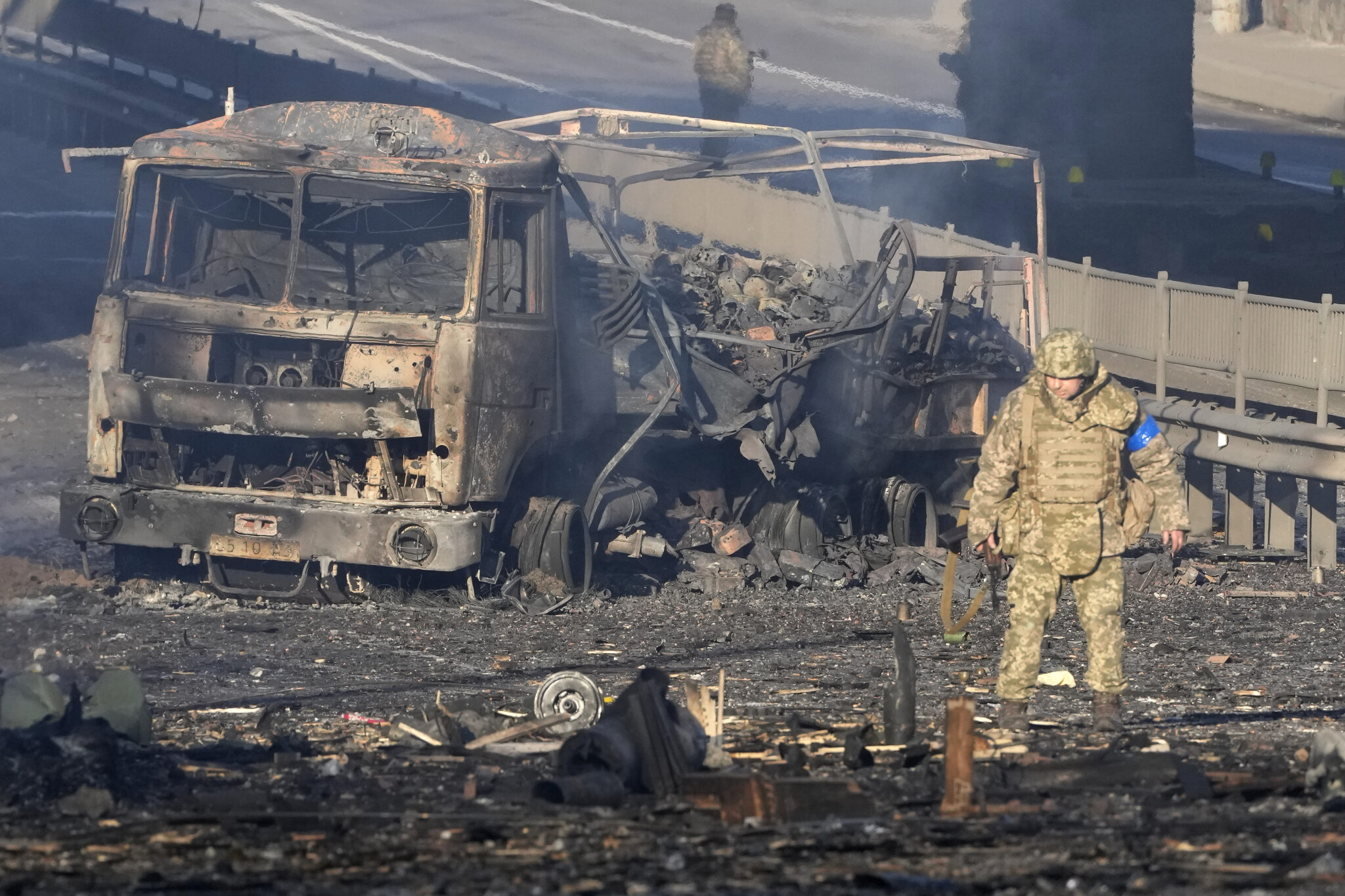 Украинский солдат проходит мимо обломков горящего военного грузовика на одной из улиц Киева. Украина. 26 февраля 2022 г. .Фото Efrem Lukatsky/AP Photo/Scanpix/Leta