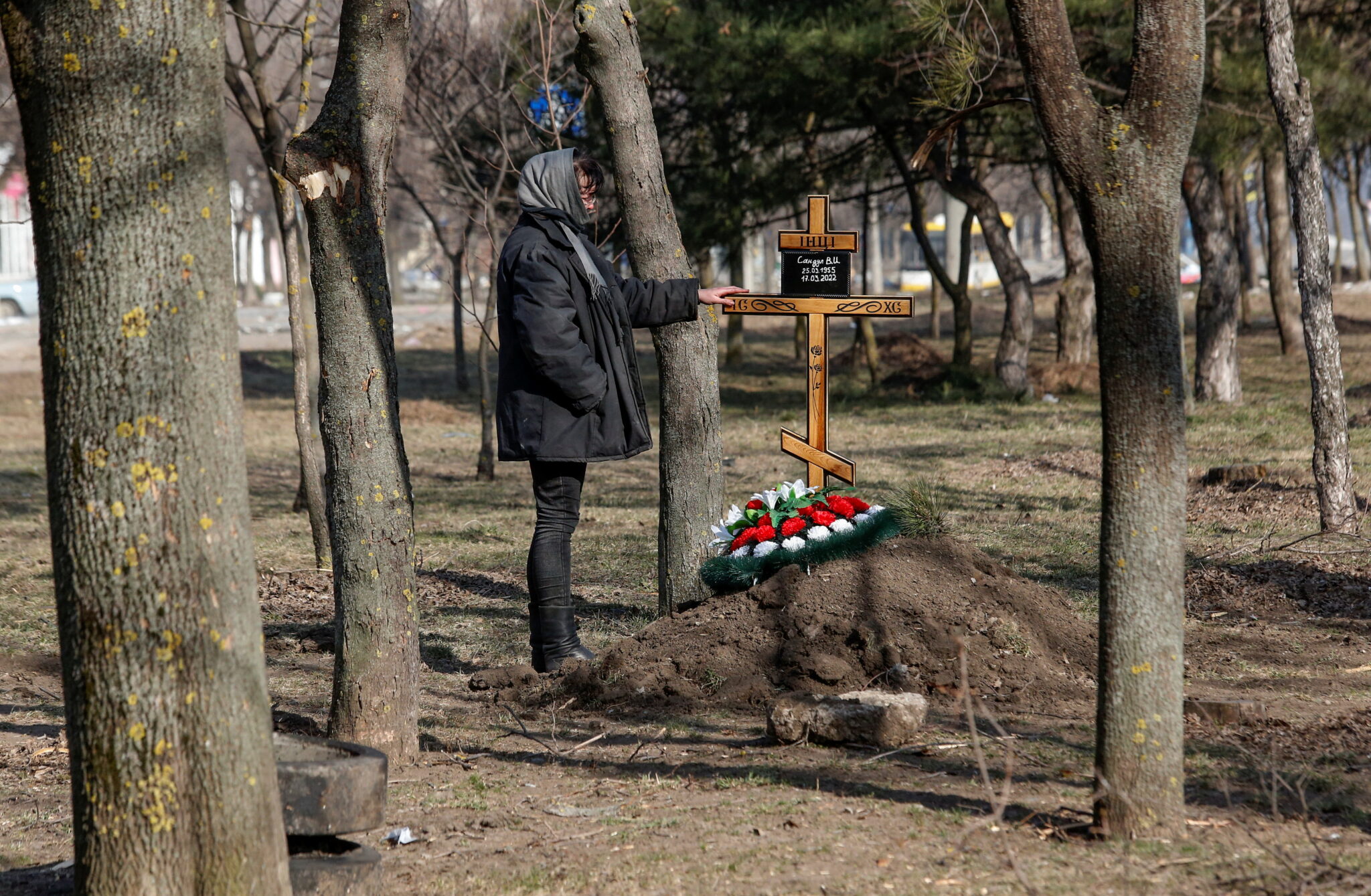 Женщина у могилы матери, погибшей в результате обстрела в осажденном южном порту Мариуполя, Украина, 23 марта 2022 года. © Reuters / Alexander Ermochenko / Scanpix / Leta