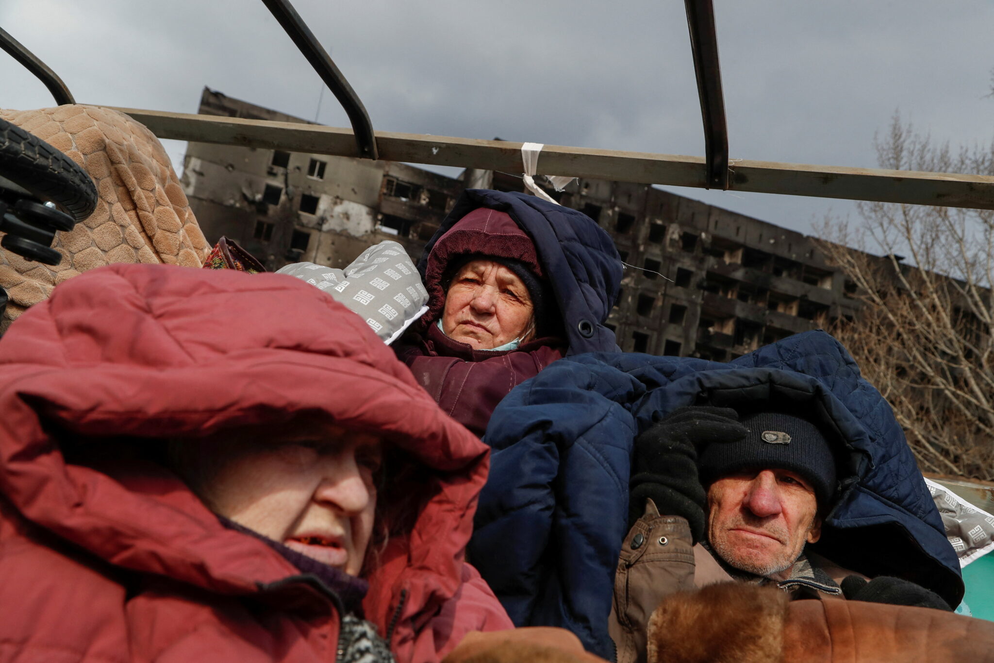 Эвакуированные, спасающиеся от украинско-российского конфликта, сидят в кузове грузового автомобиля, ожидая своей очереди на выезд из осажденного Мариуполя. 17 марта 2022 г. © REUTERS / Alexander Ermochenko / Scanpix / Leta 