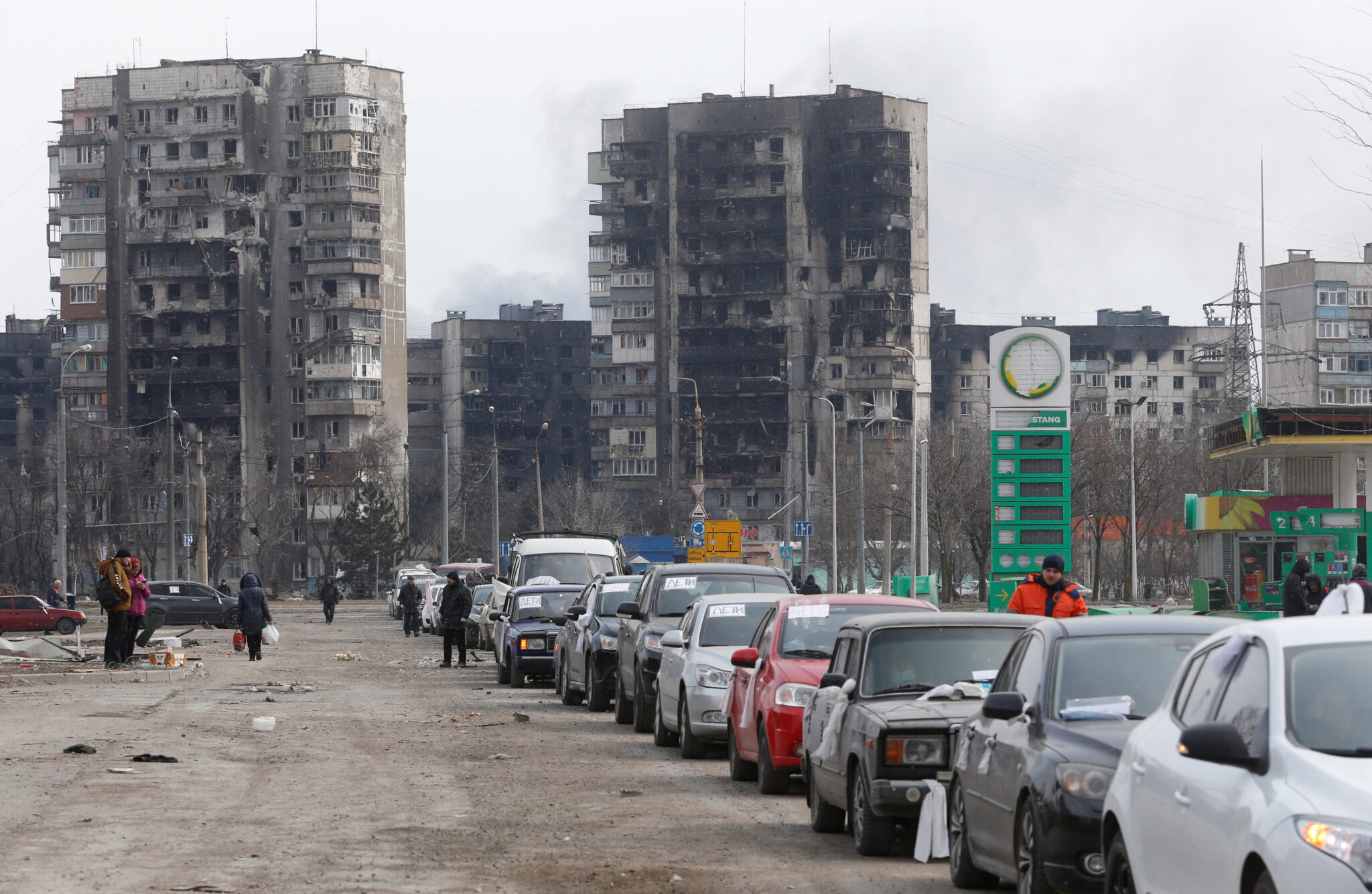  Вереница автомобилей, покидающих город, в микрорайоне, разрушенном во время обстрелов. Мариуполь, Украина, 17 марта 2022 года. © REUTERS / Alexander Ermochenko / Scanpix / Leta 