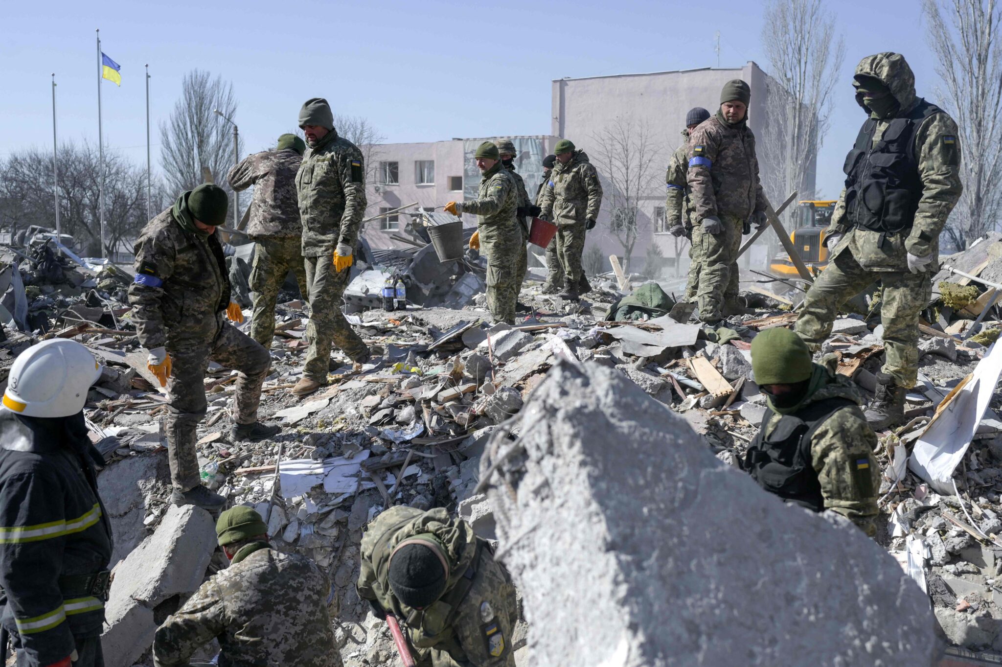 Солдаты разгребают завалы уничтоженного российскими ракетами военного училища в Николаеве. 19 марта 2022 года. Фото BULENT KILIC/AFP/Scanpix/Leta