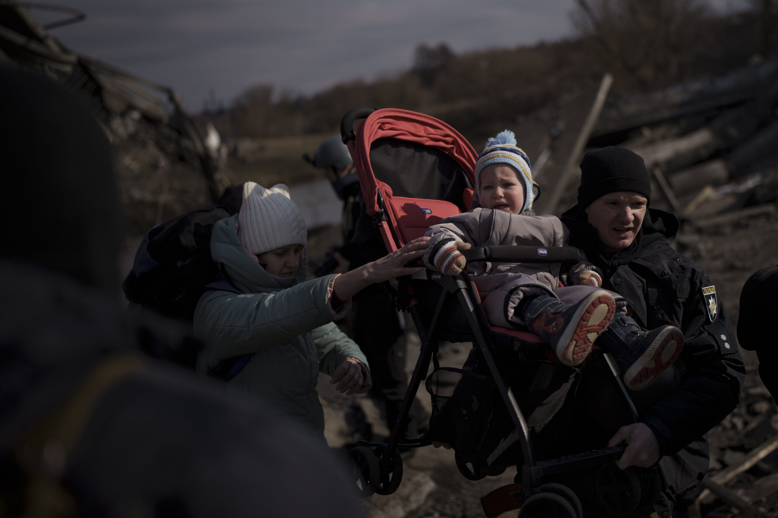 Ребенка несут в коляске во время бегства из города Ирпень. Окраина Киева. 9 марта 2022 года. Фото Felipe Dana/AP Photo/Scanpix/LETA