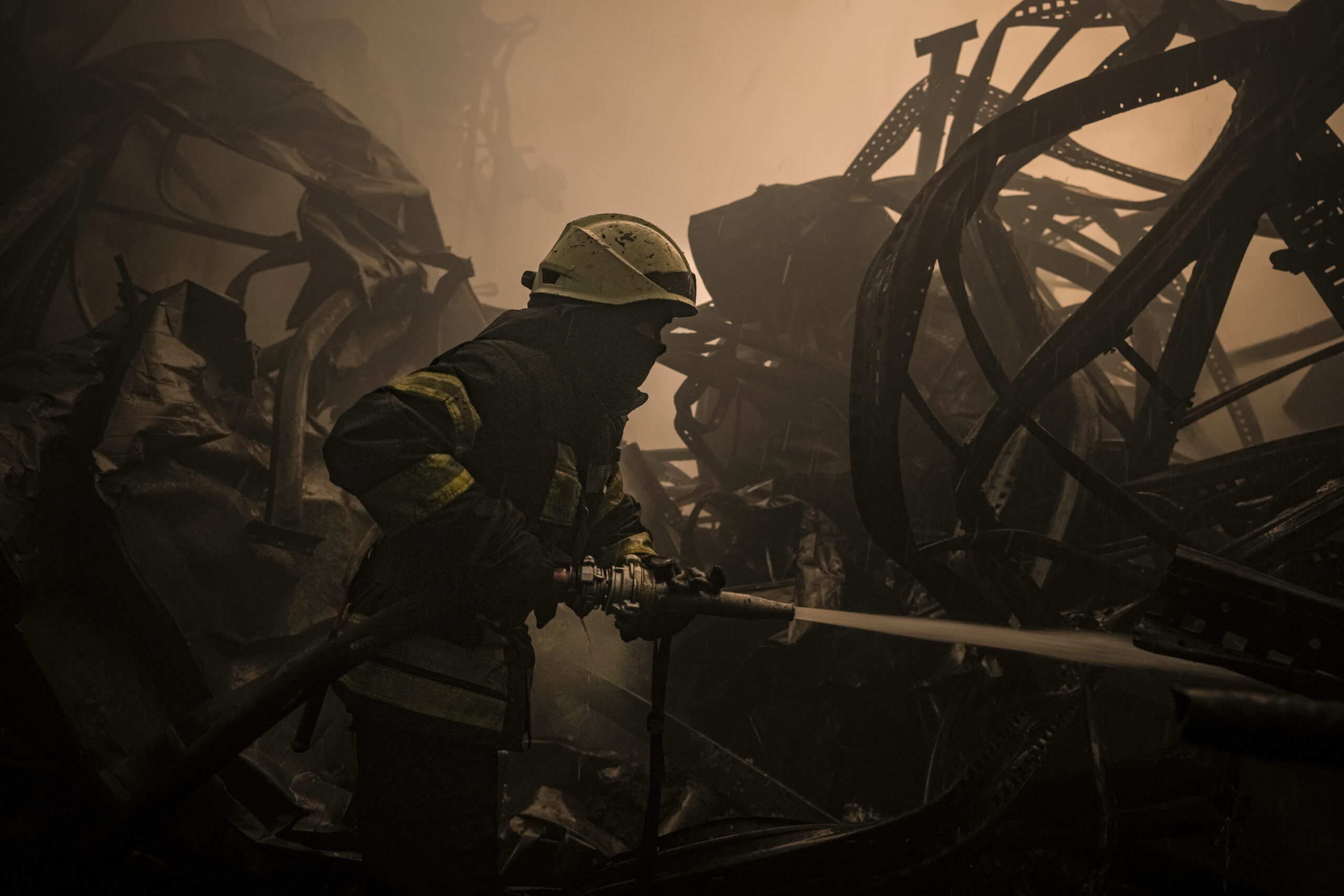Украинский пожарный тушит пожар на крупном складе продуктов питания, который был уничтожен в результате авиаудара рано утром на окраине Киева. Украина 13 марта 2022 года. Фото Vadim Ghirda/AP Photo/Scanpix/Leta