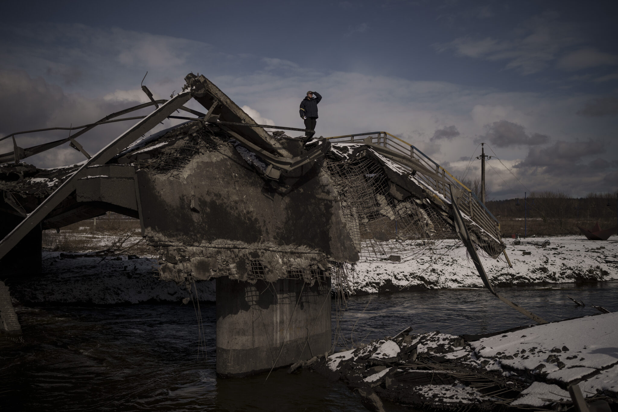 Мужчина стоит на разрушенном мосту в Ирпене на окраине Киева. 8 марта 2022 года. Фото Felipe Dana/AP Photo/Scanpix/LETA