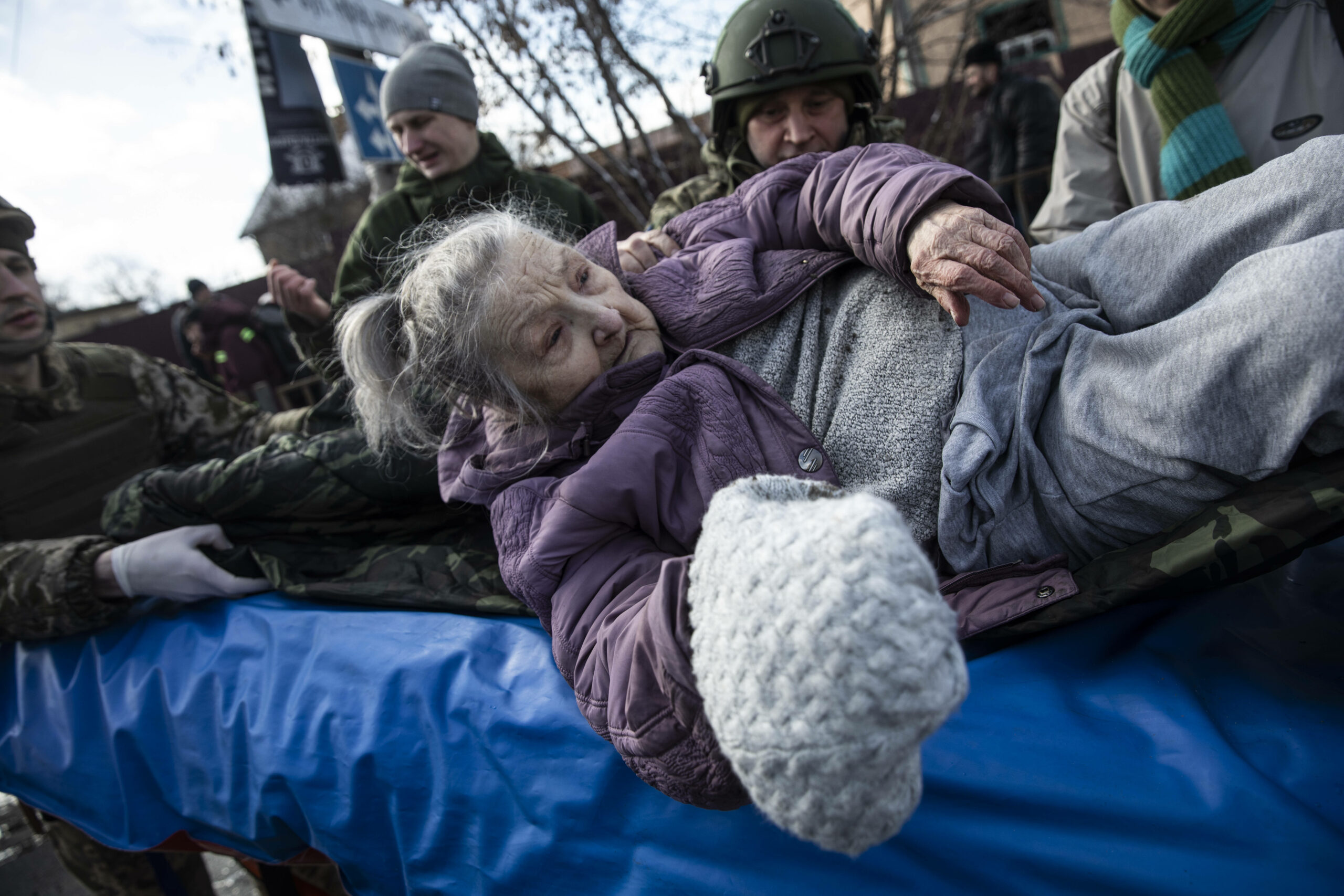 Участники территориальной самообороны помогают эвакуировать пожилую женщину из города Ирпин в Киев. 8 марта 2022 года. Фото Heidi Levine/Sipa Press/Scanpix/LETA