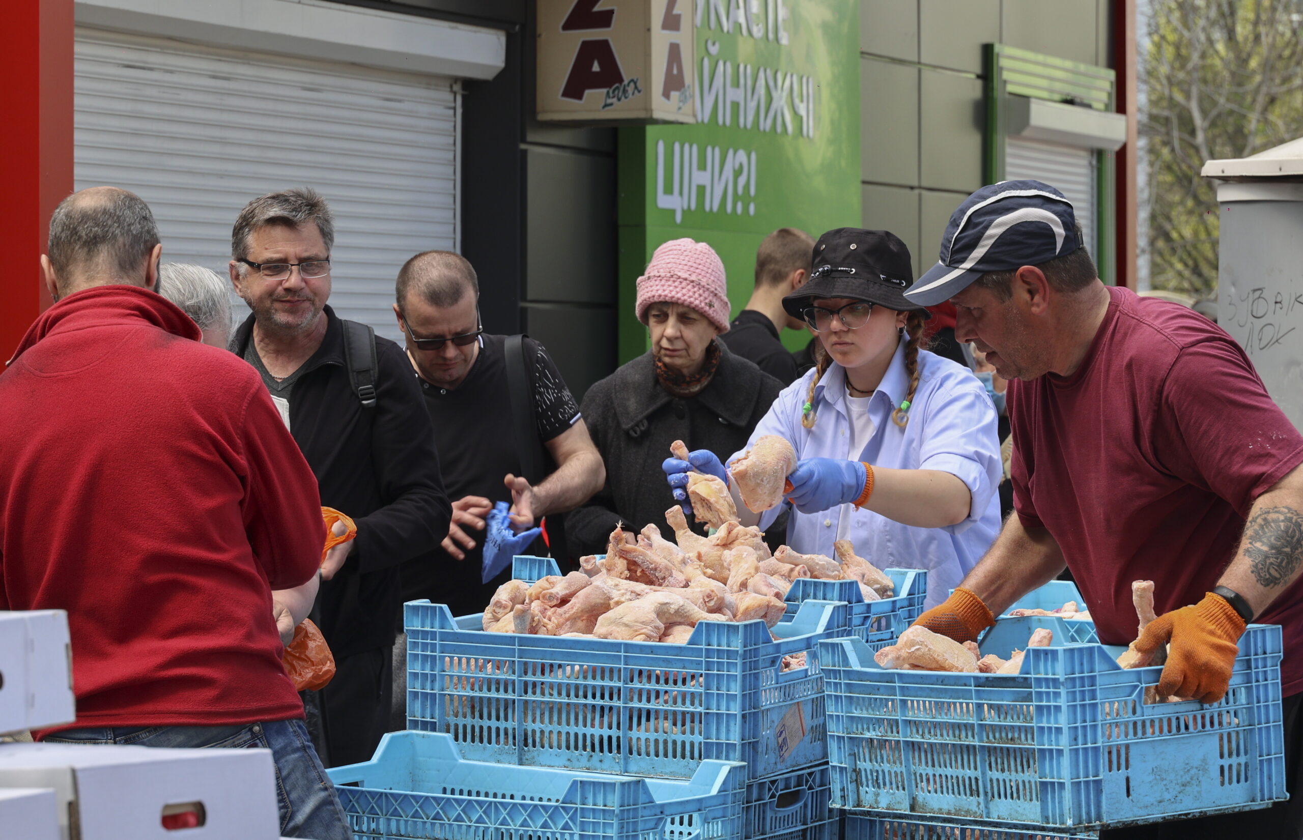 Местные жители стоят в очереди за куриным мясом, которое раздают в качестве гуманитарной помощи, по три штуки на человека. Харьков. 26 апреля 2022 года. Фото EPA/SERGEY KOZLOV/Scanpix/LETA