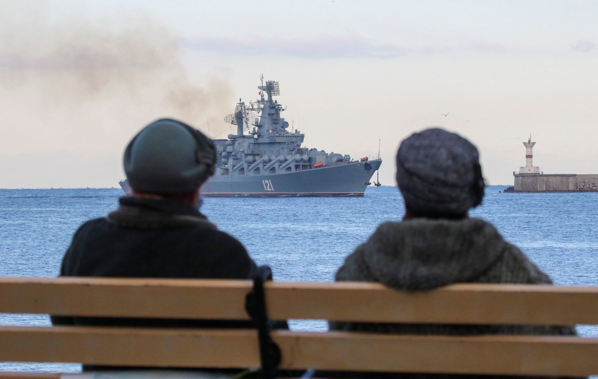 Женщины смотрят на флагман Черноморского флота, ракетный крейсер “Москва” в порту Севастополя. 16 ноября 2021 года. Фото REUTERS/Alexey Pavlishak/Scanpix/LETA
