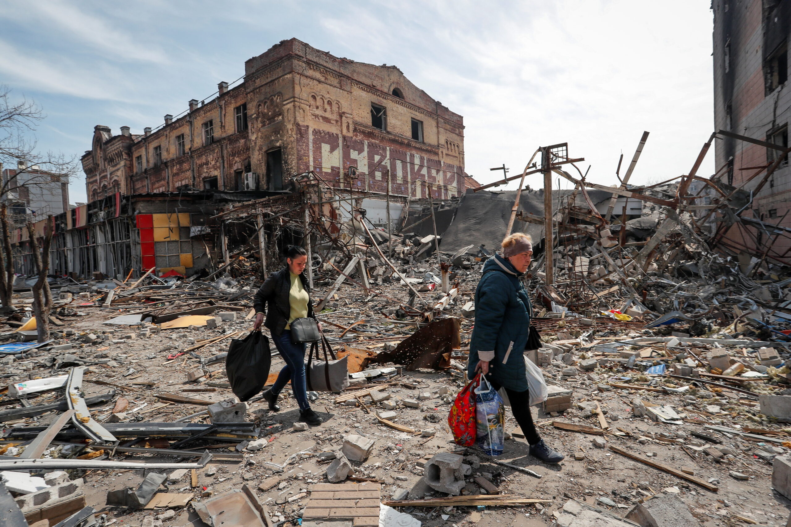 Жители Мариуполя идут мимо разрушенного здания. 10 апреля 2022 года.Фото REUTERS/Alexander Ermochenko/Scanpix/LETA