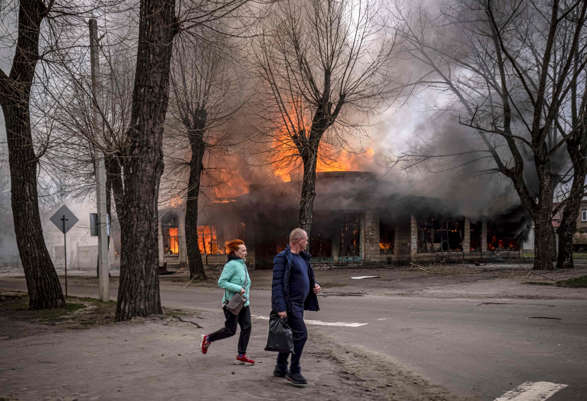Жители бегут возле горящего дома после обстрела Северодонецка. Донбасс. Украина. 6 апреля 2022 года. Фото FADEL SENNA/AFP/Scanpix/LETA
