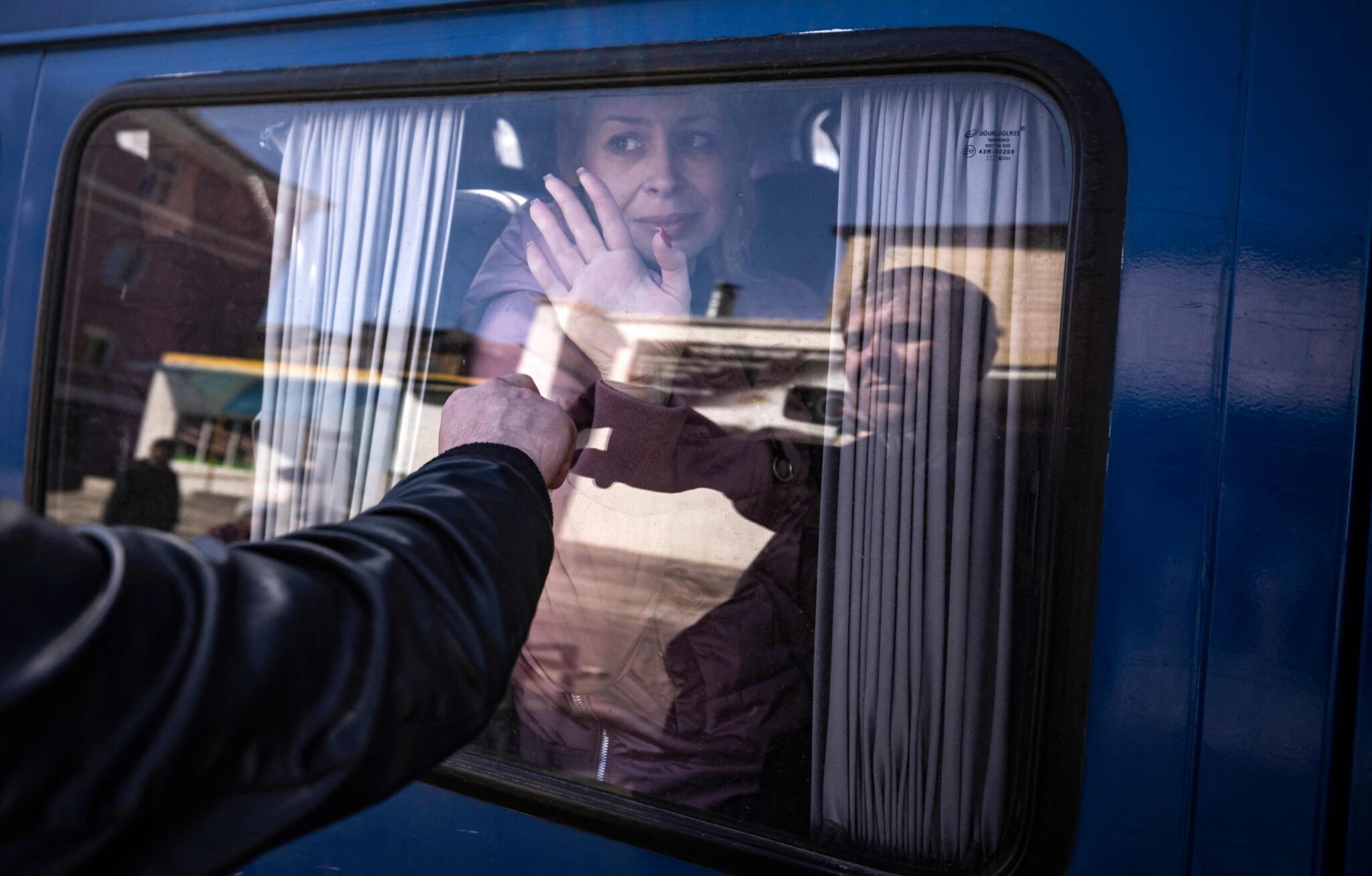 Женщина прощается с мужем через окно автобуса через день после ракетного обстрела железнодорожного вокзала в Краматорске. Украина, 9 апреля 2022 года © Fadel Senna / AFP / Scanpix / Leta
