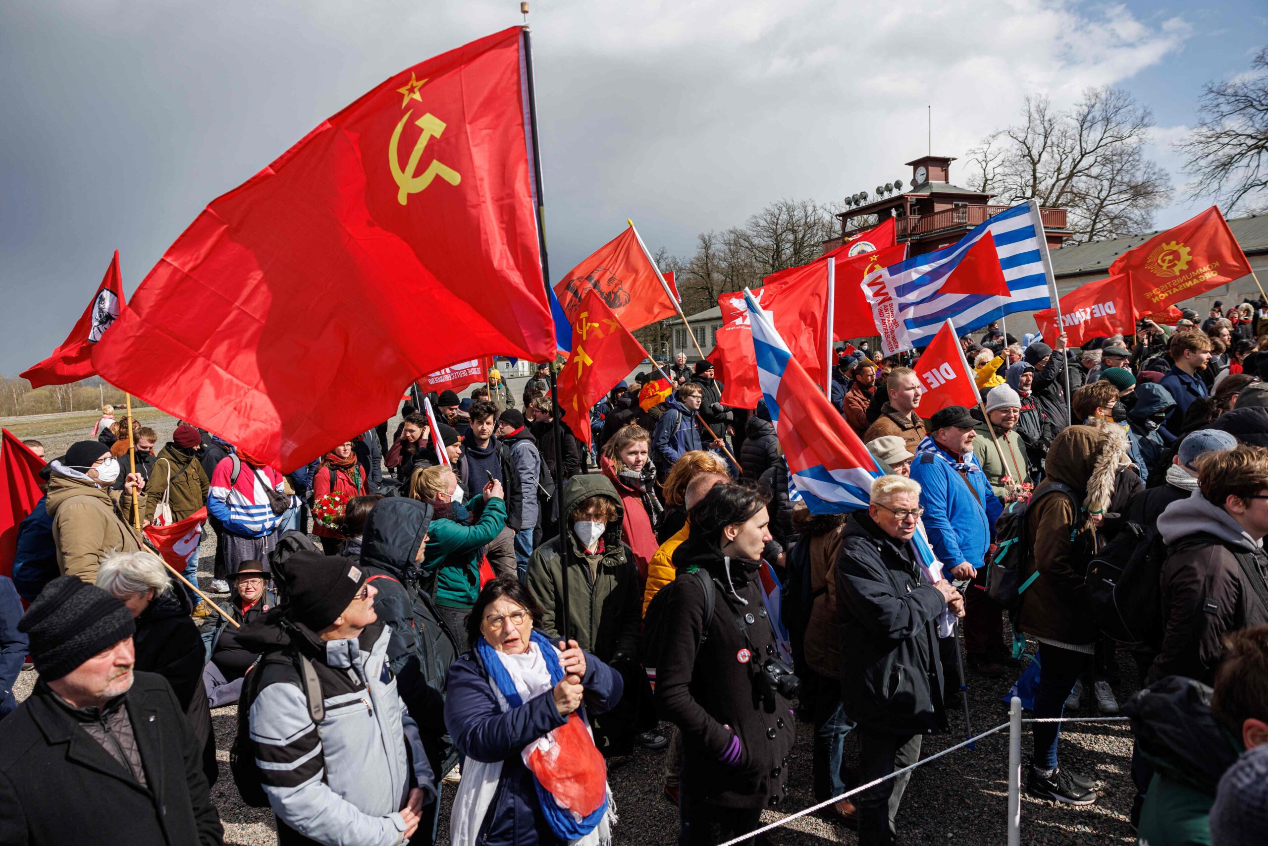 Люди с советскими флагами идут на торжественную церемонию по случаю 77-й годовщины освобождения нацистского концлагеря Бухенвальд. Веймар. Германия. 10 апреля 2022 года. Фото JENS SCHLUETER/AFP/Scanpix/LETA  
