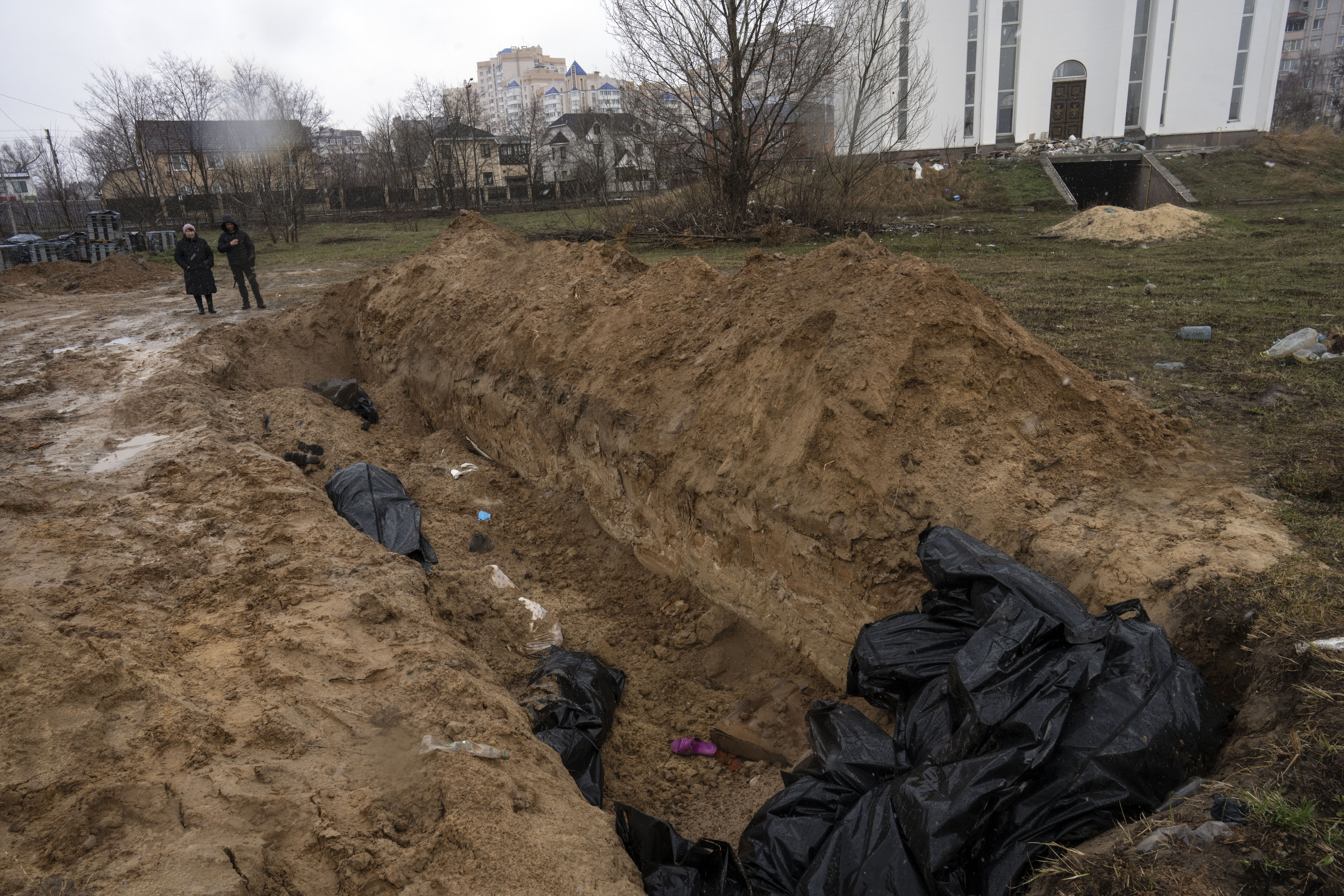 Люди собираются у братской могилы в Буче на окраине Киева. 3 апреля 2022 года. Фото Rodrigo Abd/AP Photo/Scanpix/LETA