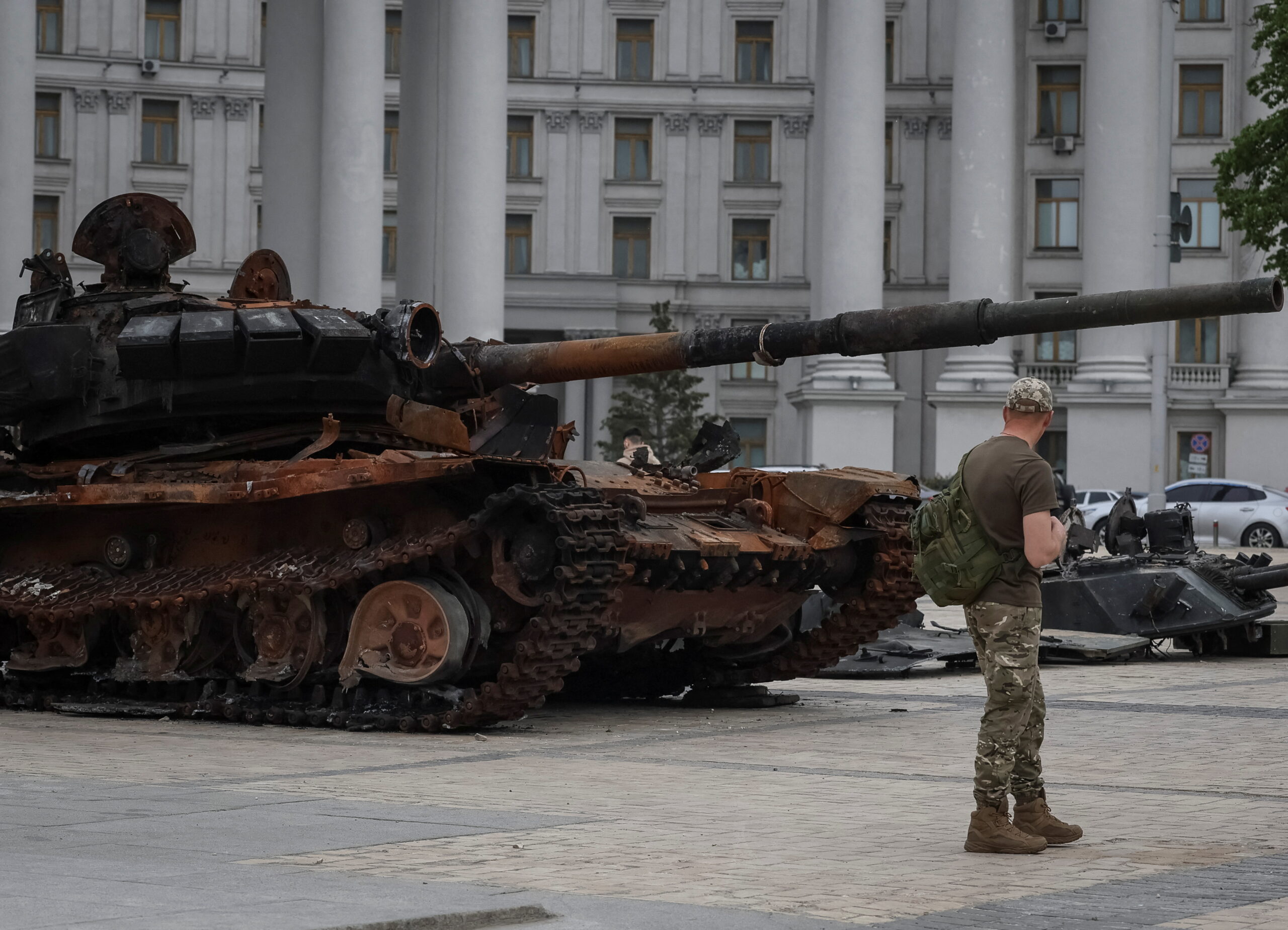 Украинский солдат смотрит на уничтоженный российский танк на Михайловской площади. Киев. 21 мая 2022 года. REUTERS/Gleb Garanich/Scanpix/LETA