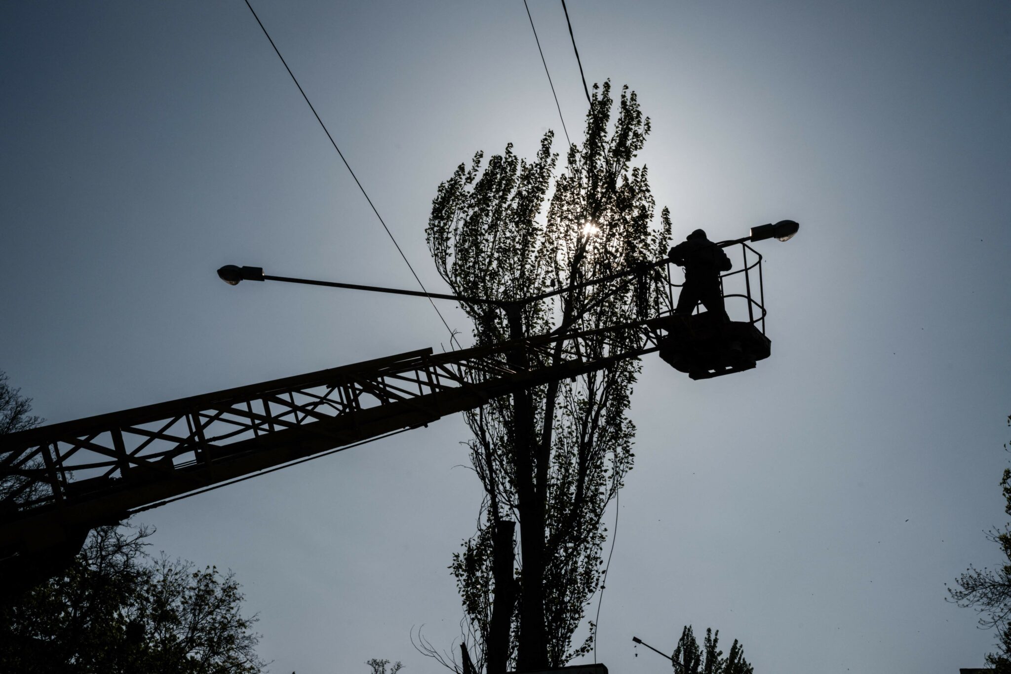 Электрик чинит линию. Фото Yasuyoshi CHIBA/AFP/Scanpix/LETA