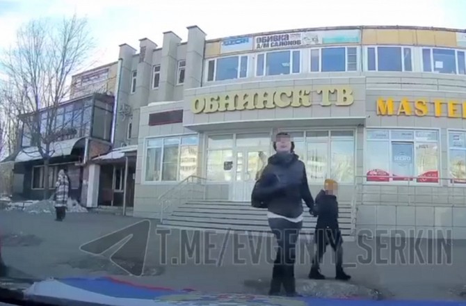 Жительница Обнинска плюет в сторону российского флага. Скриншот из телеграм-канала Евгения Серкина.