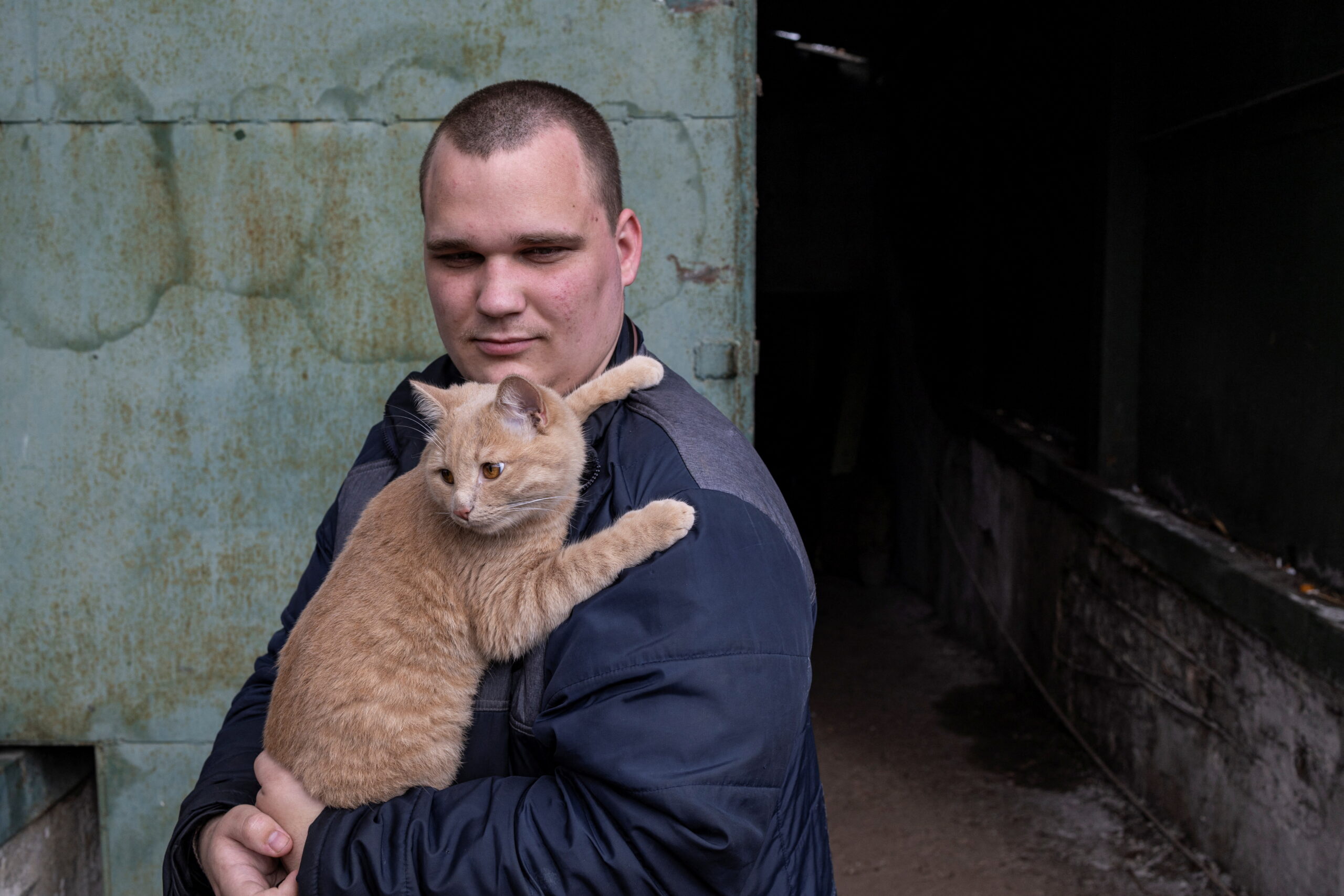 Мужчина со своим котом перед входом в убежизе на 