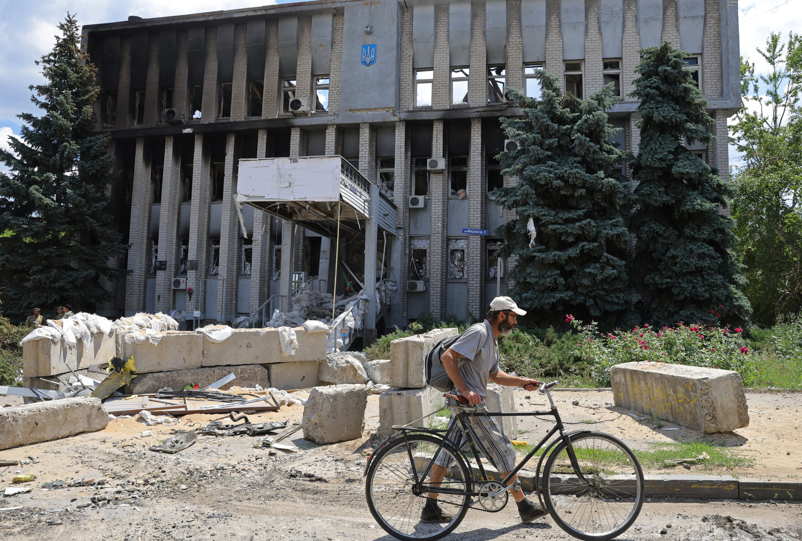 Местный житель на фоне разрушенного административного здания в Лисичанске. 4 июля 2022 года. Фото REUTERS/Alexander Ermochenko/Scanpix/LETA