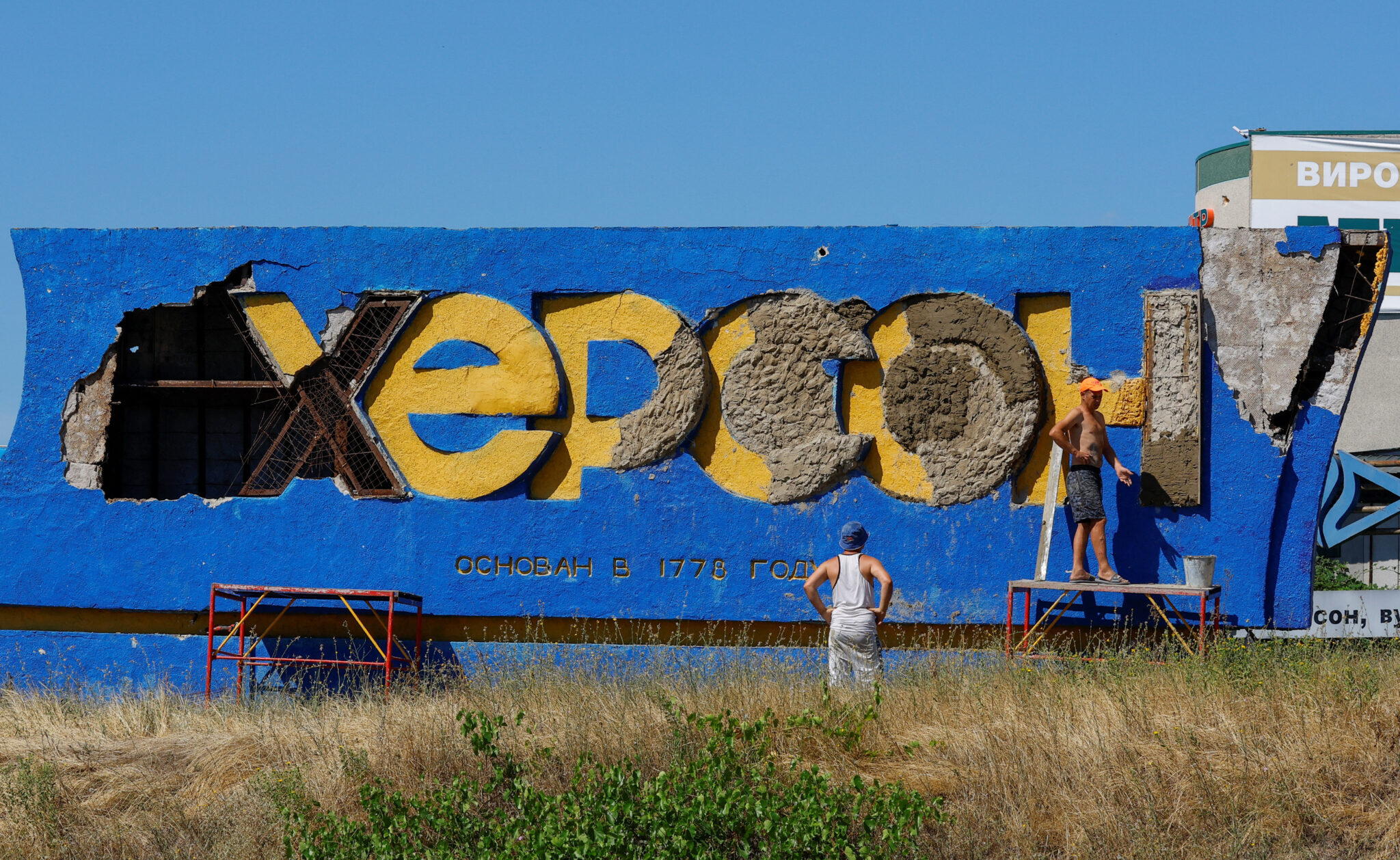 Надпись “Херсон”, рядом с обстрелянным ВСУ Антноновским мостом через Днепр. 27 июля 2022 года. Фото REUTERS/Alexander Ermochenko/Scanpix/LETA
