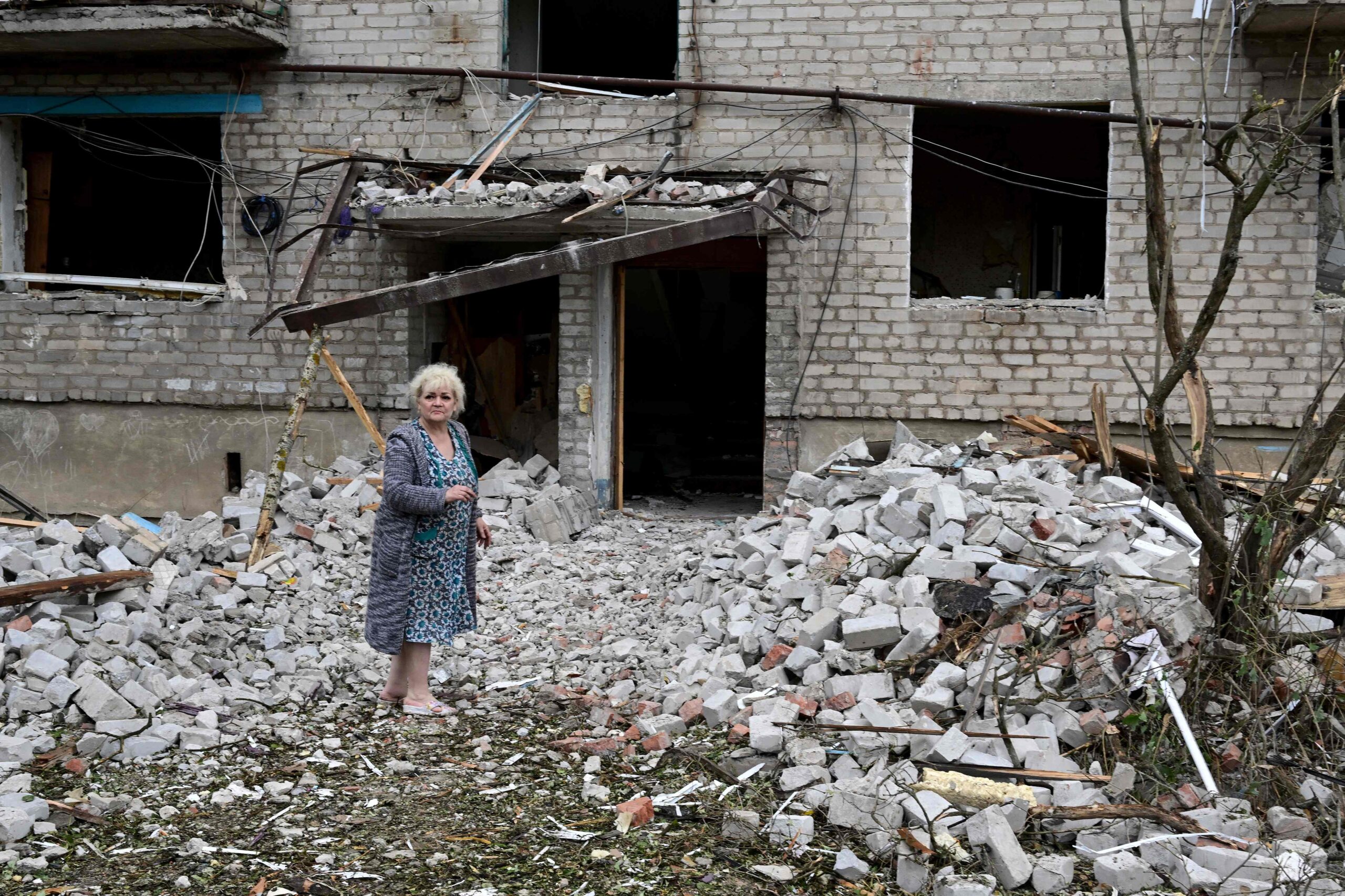 Жительница на фоне разрушенного ударом дома. Часовой Яр, Донецкая область. 10 июля 2022 года. Фото MIGUEL MEDINA/AFP/Scanpix/LETA