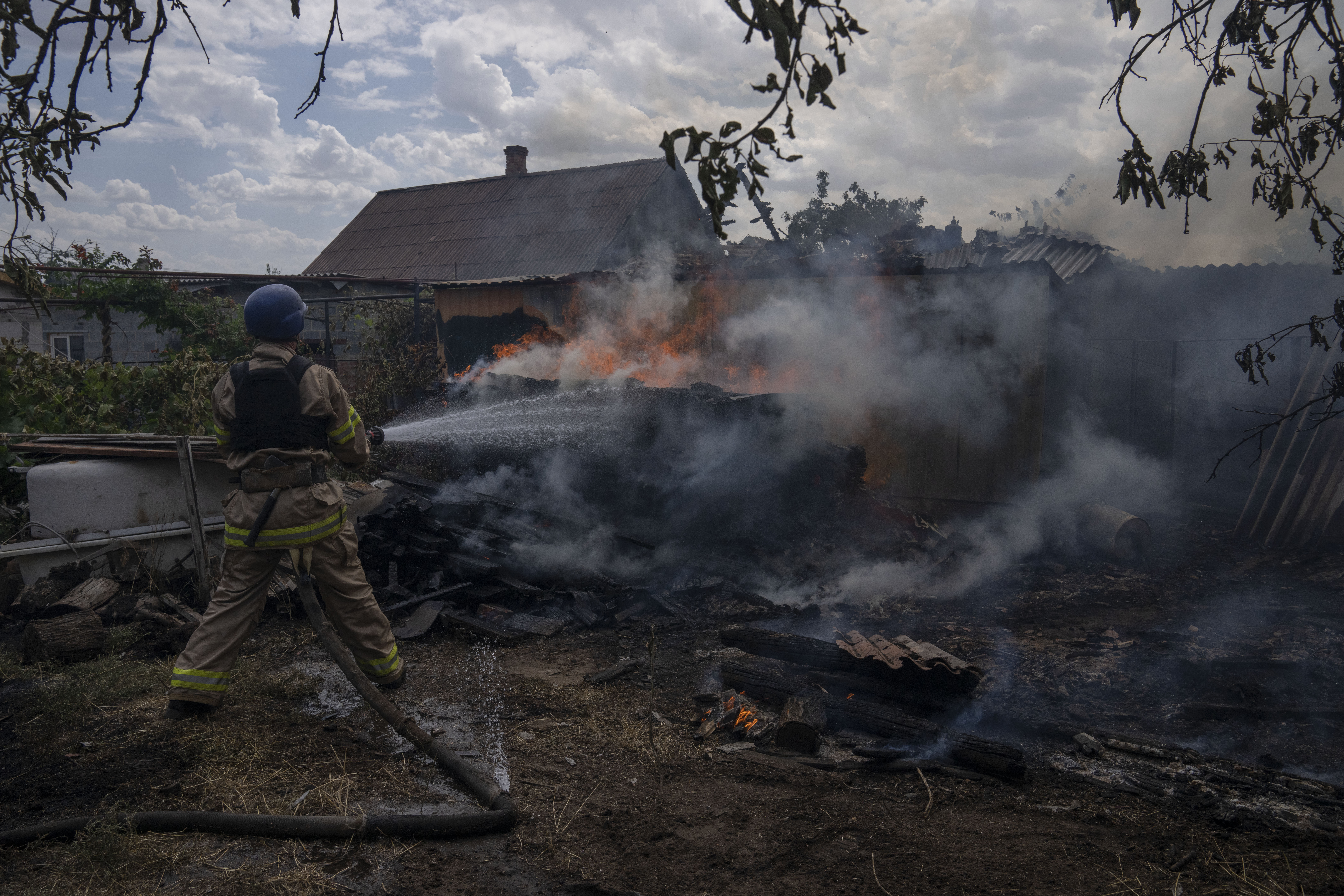 Пожарный тушит дом, загоревшийся после обстрела Константиновки. 9 июля 2022 года. Фото AP Photo/Nariman El-Mofty/Scanpix/LETA