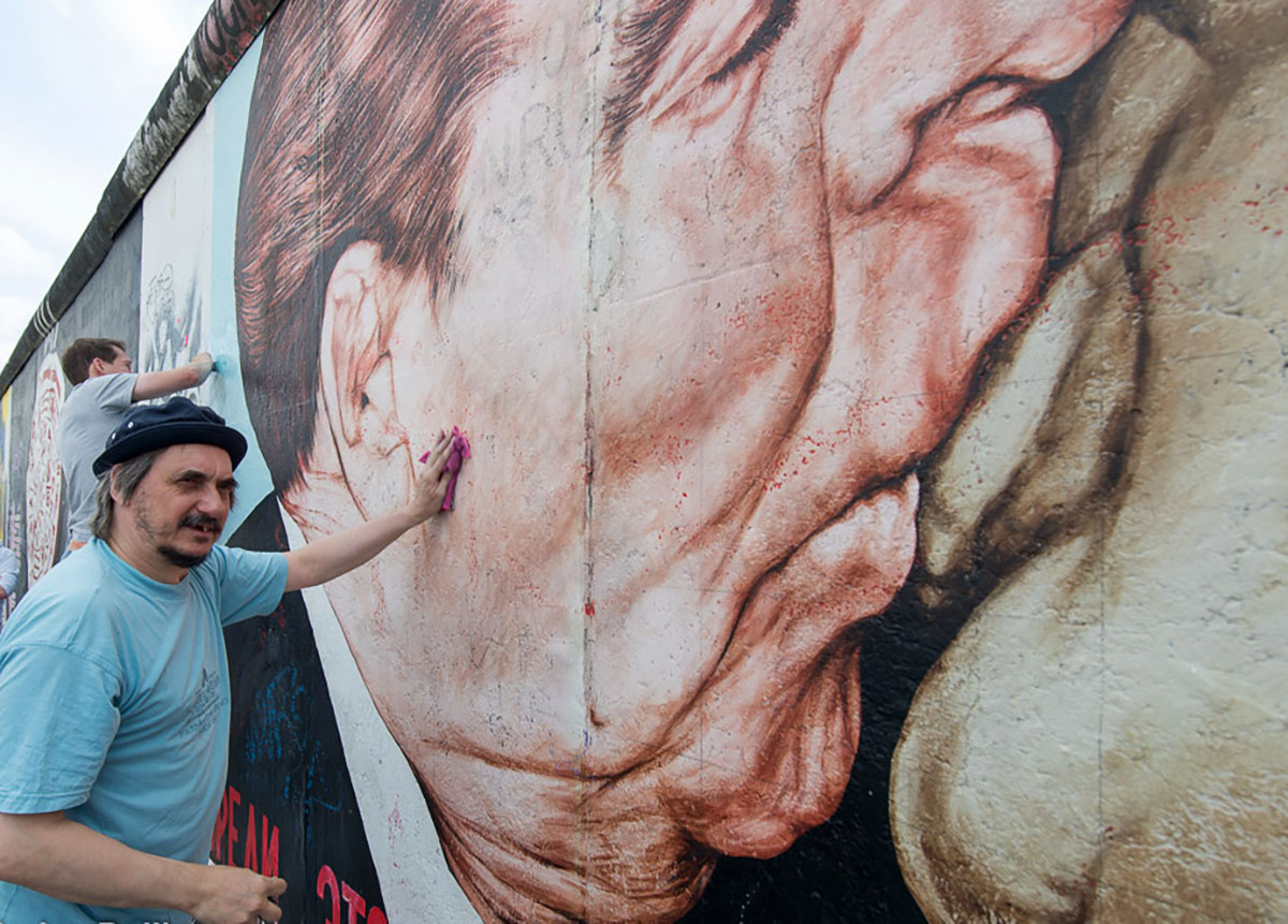 Дмитрий Врубель рядом с граффити «Братский поцелуй» на Берлинской стене. Фото Florian Boillot по лицензии Flickr