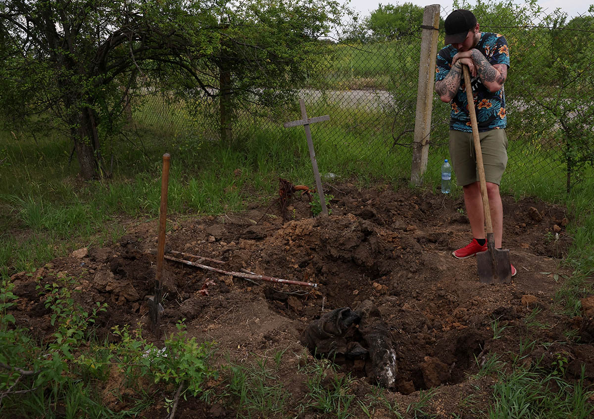 Волонтер раскапывает останки российского солдата, недалеко от Харькова. Фото Leah Millis/REUTERS/Scanpix/Leta